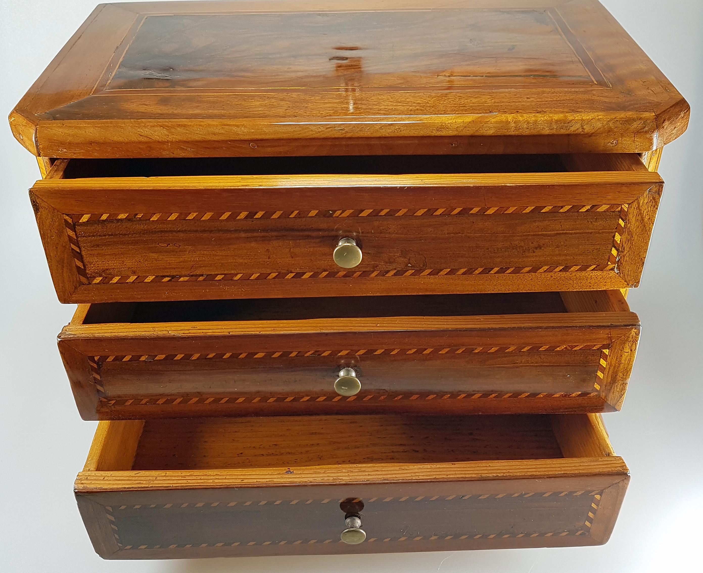 Model Furniture - Louis XVI dresser, southern Germany, 1800s. Made of walnut and other fine woods. A rare collector's item of high historical value. 

Body with chamfered corners, three drawers with circumferential fillet ribbon inlays, sides and