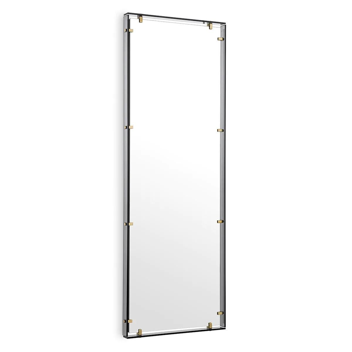 Elegante e sofisticato, questo grande specchio incarna lo stile contemporaneo con la sua silhouette composta da vari materiali disposti in modo da creare una forma distintiva.
La cornice rettangolare in vetro fumé presenta tocchi di ottone antico