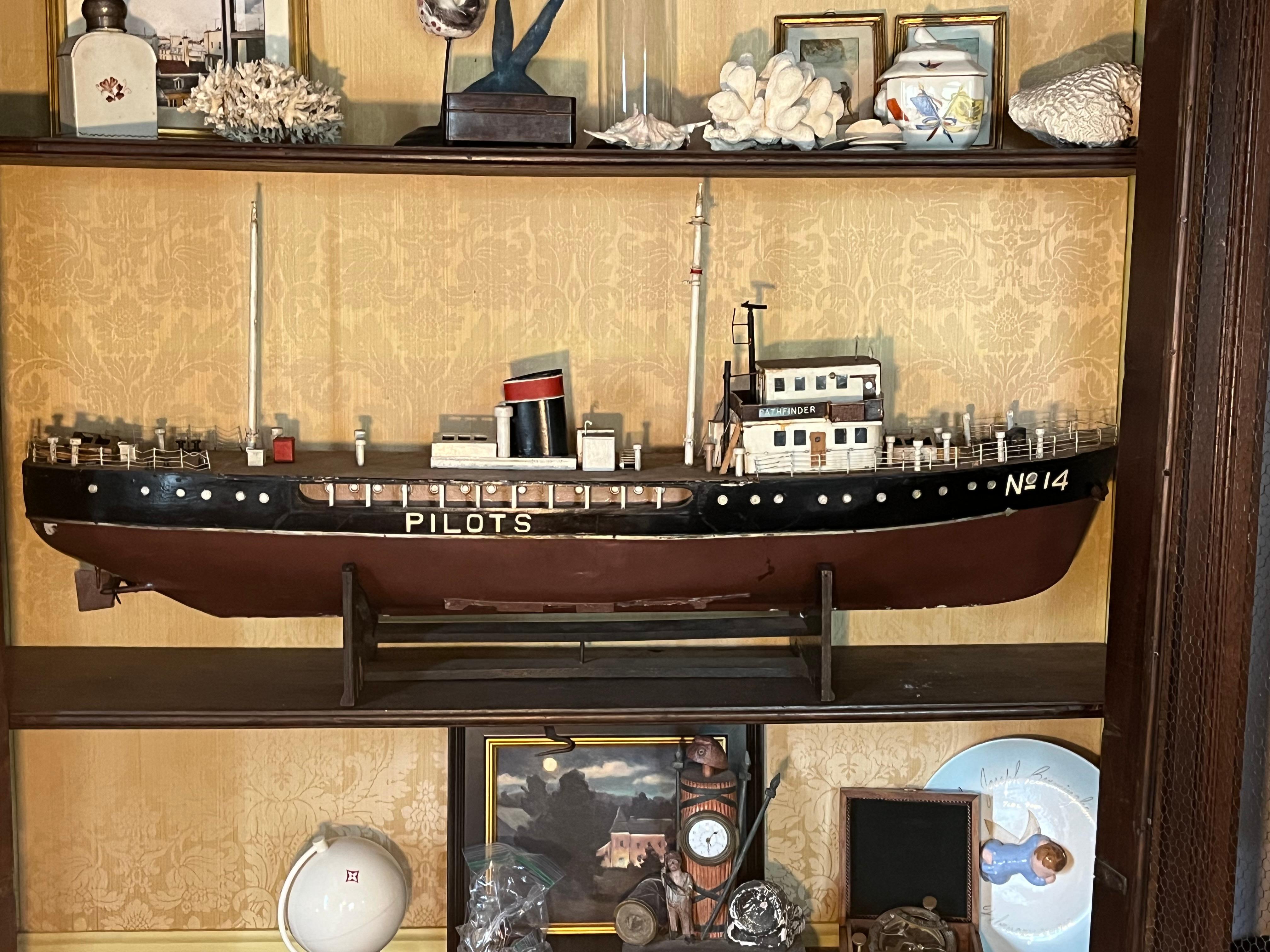 An interesting and finely detailed hand-made model of Pathfinder, an early 20th century pilot ship. Ships such as these were (and still are) invaluable in maneuvering larger ships into and out of berths and harbors. The model sits in a custom cradle
