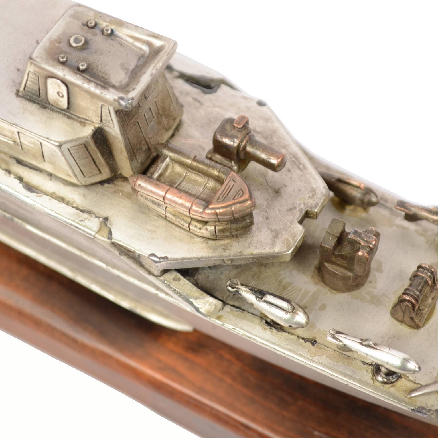 Model of an Italian Navy 5500 ship, made of chromed brass and mounted on a wooden base; made in the 1970s. Measurements of the base cm 35.5 x 5 x total height 7.7 cm. Very good condition.