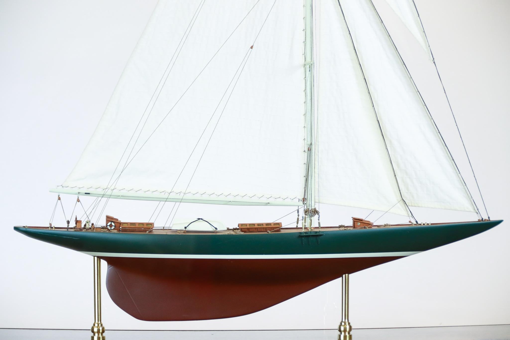 Model of Sir Thomas Lipton's America's Cup challenger Shamrock V. Deck is detailed with lifeboat, rope, cabins, hatches, binnacle, capstan, wheel and others. Model is mounted into a brass trimmed case. A custom table Stand is available and not