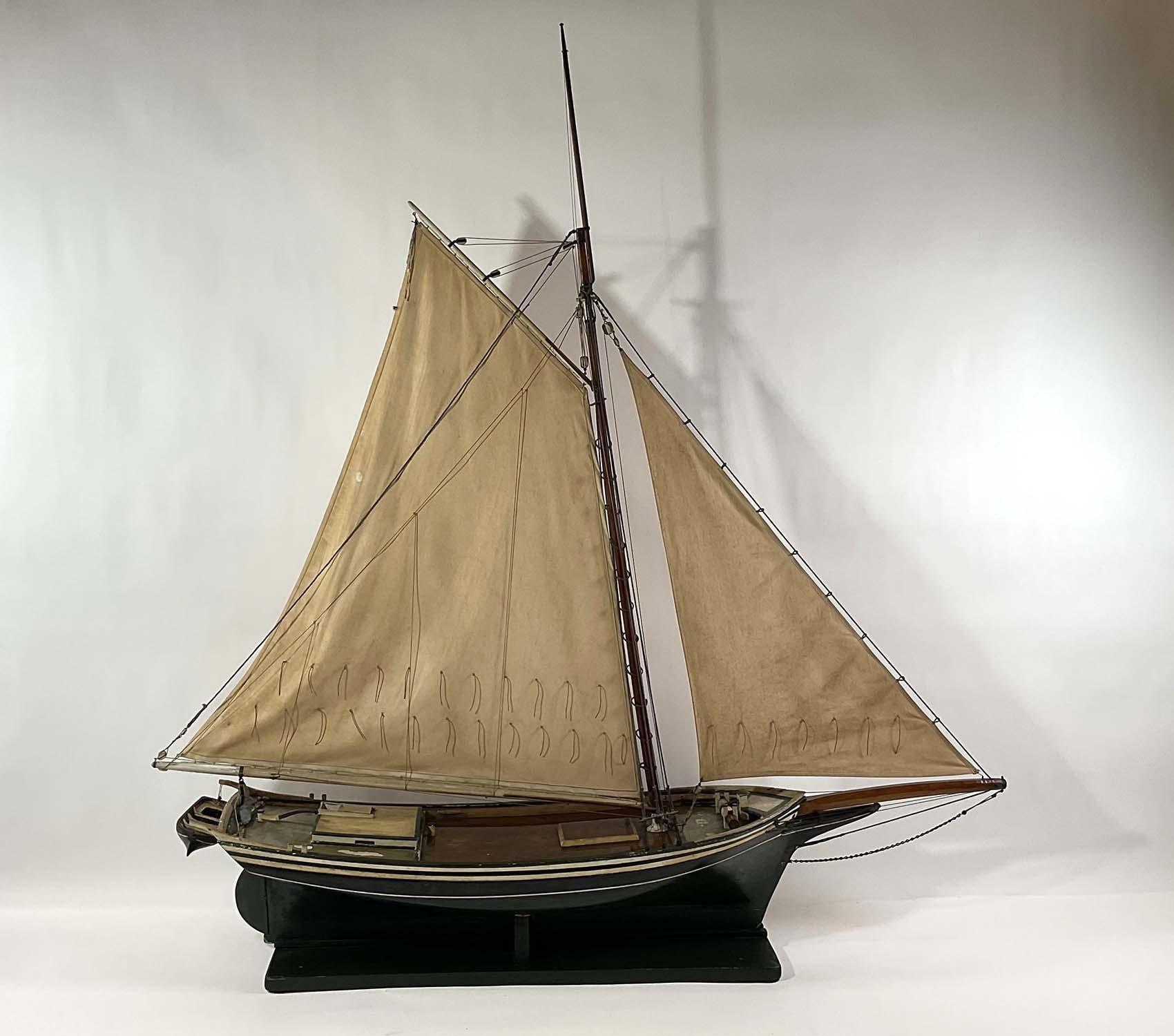 Period model of the sloop Fanny Fern of Quincy Mass. Exceptional antique model that shows the craft in great detail including the bulwarks, cabin, hatch, launch, winch, etc. Fitted with a pair of accurate sails. Set on a wood cradle. Late nineteenth