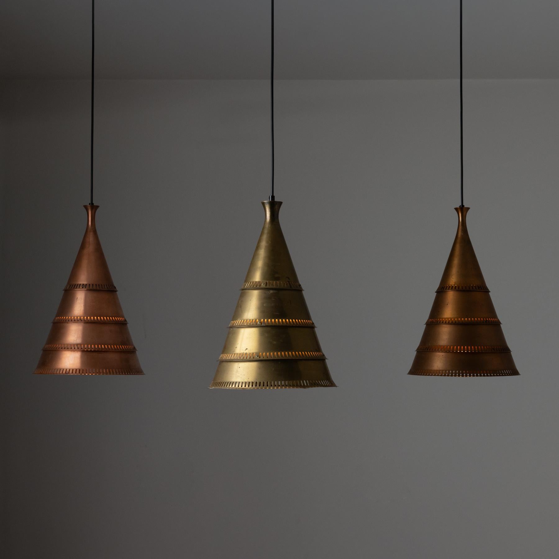 Pendants by Lyfa. Manufactured in Denmark, circa 1960s. These conical shades are photographed as a trio. Each shade is slightly different, one being aged brass, and the other two aged copper, from different time points. Please ask rewire if you have