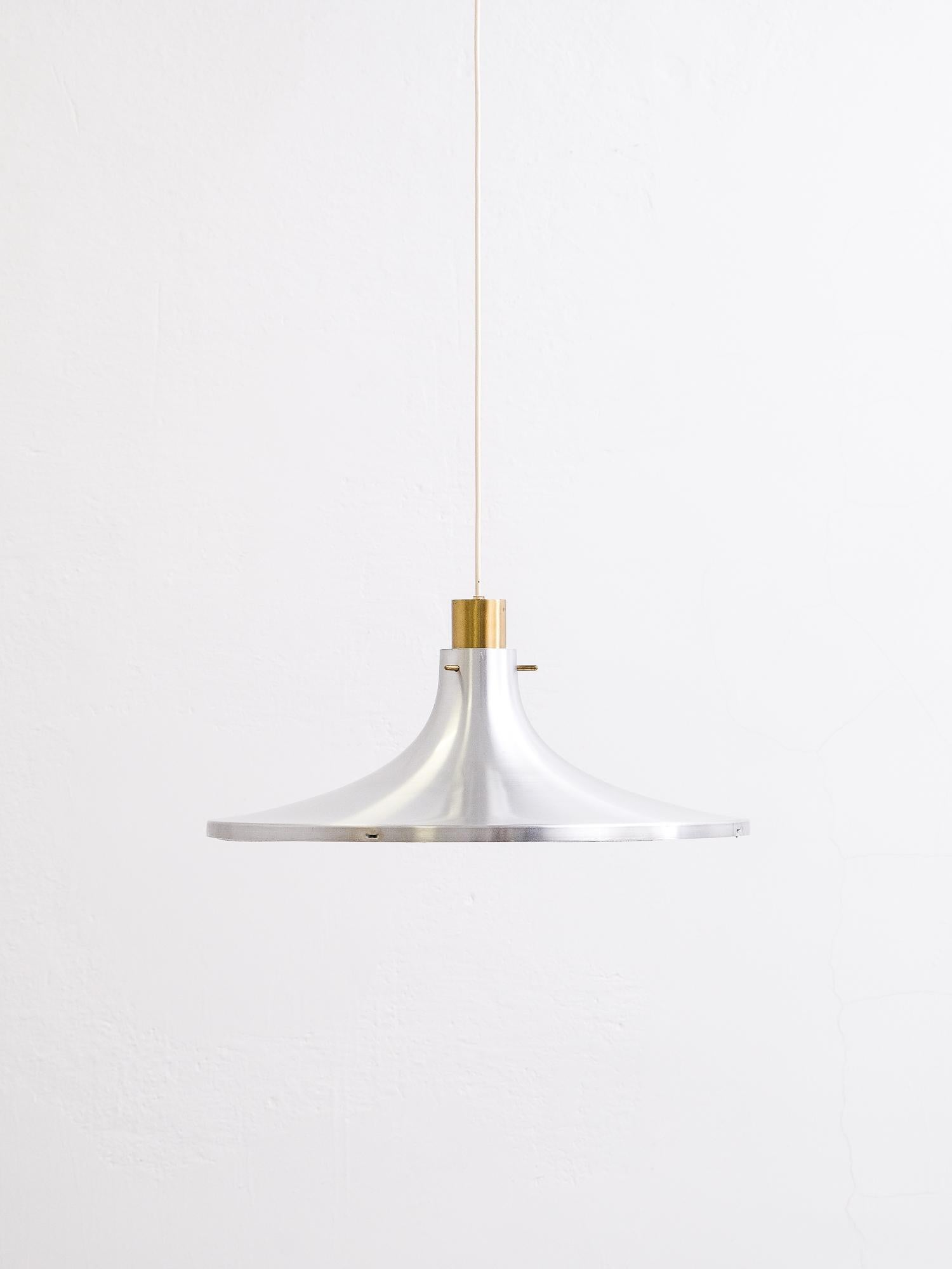 This lamp was designed by Hans-Agne Jakobsson in the 1960s and manufactured by Hans Agne Jakobsson AB in Markaryd, Sweden. It is made from an aluminium tulip formed shade in 60 cm diameter and a brass fixation at the top. The light comes with