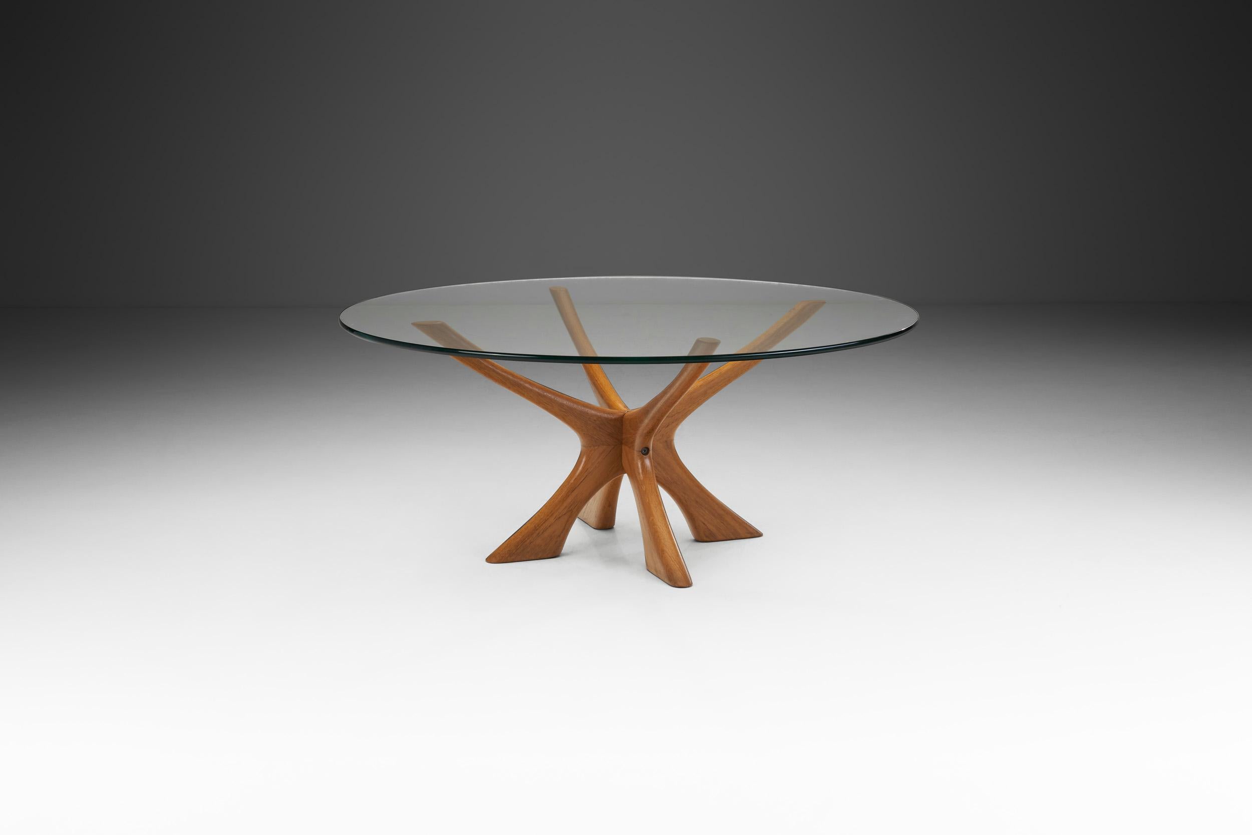 This immediately recognizable model, the “T118” is a Danish modern classic with a glass top and a solid, sculptural wood base. Designed by Illum Wikkelsø, this table always makes a lasting impression in any interior.

The form has an inherently