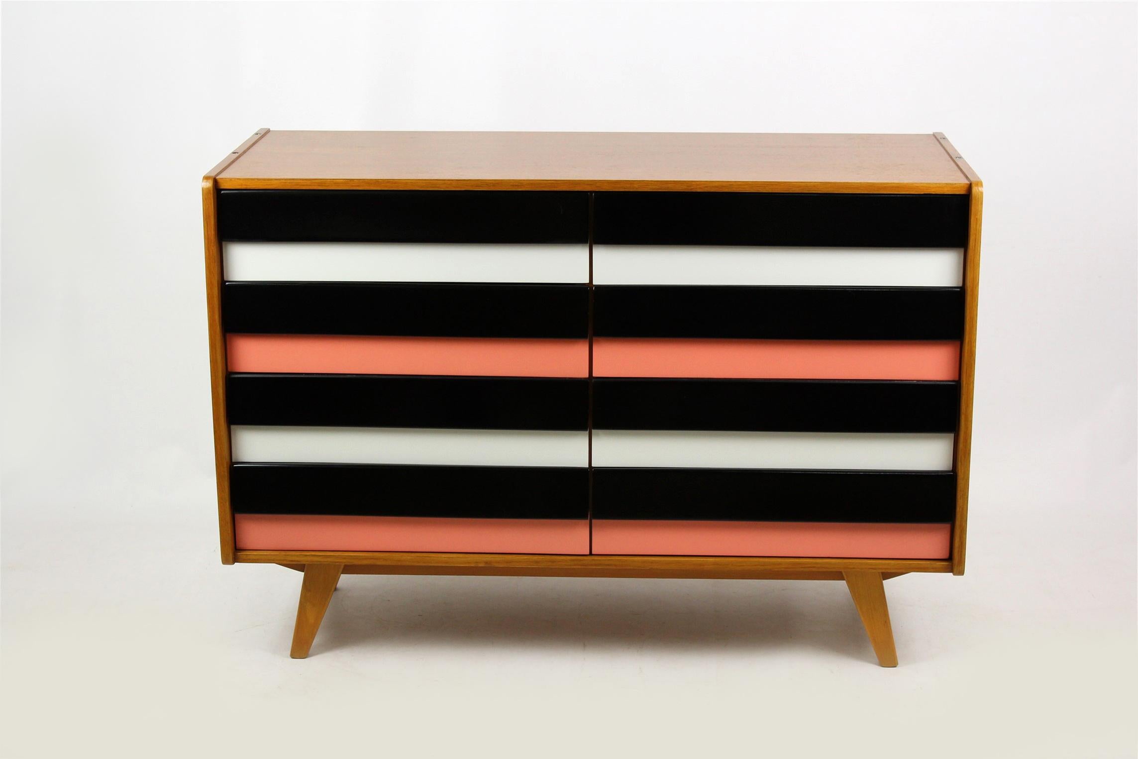 This midcentury wooden chest of drawers was designed by Jirí Jiroutek for Interiér Praha in the 1960s. Woodwork has been completely restored, finished in satin varnish. Pink and white/black fronts kept in original, good condition.