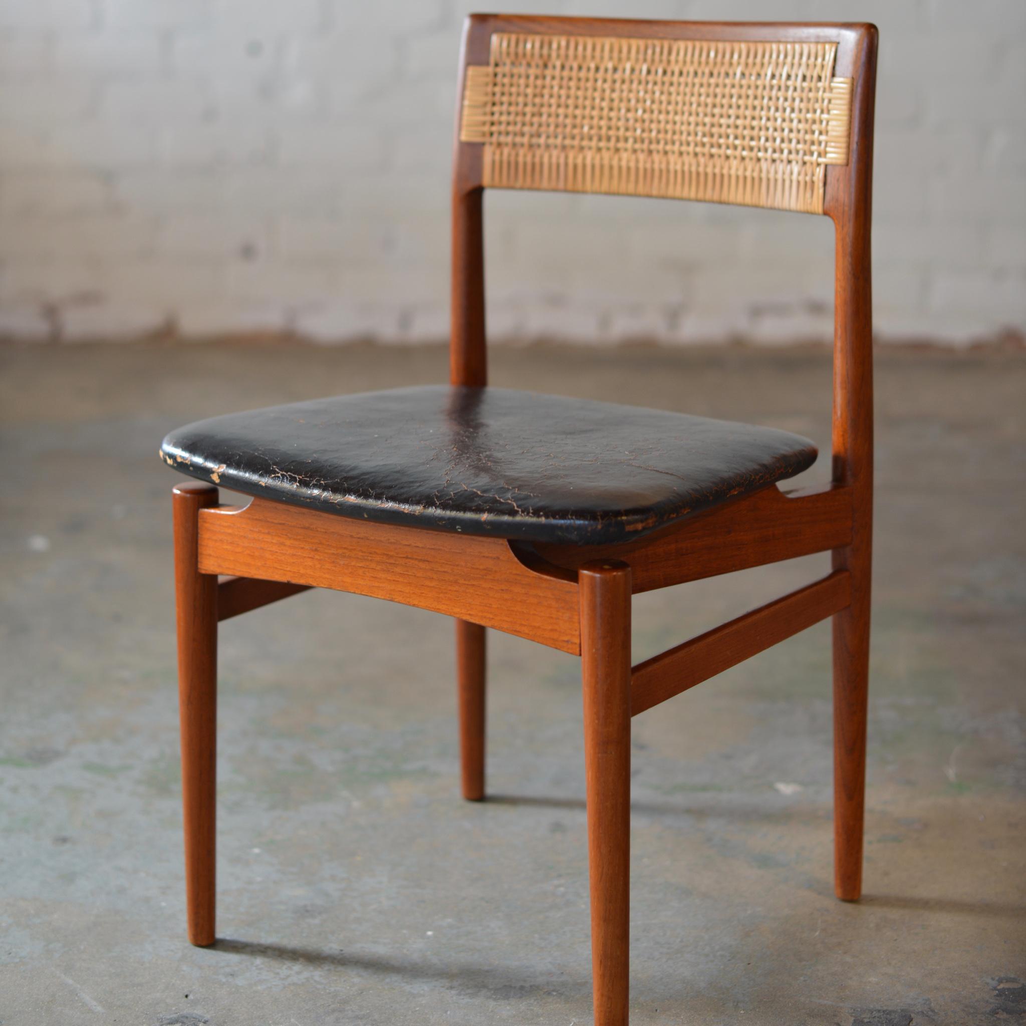 A set of seven teak side chairs by Erik Worts with leather seats and caned back rests. Newly re-caned backs with a beautiful wear on the leather seat.
 