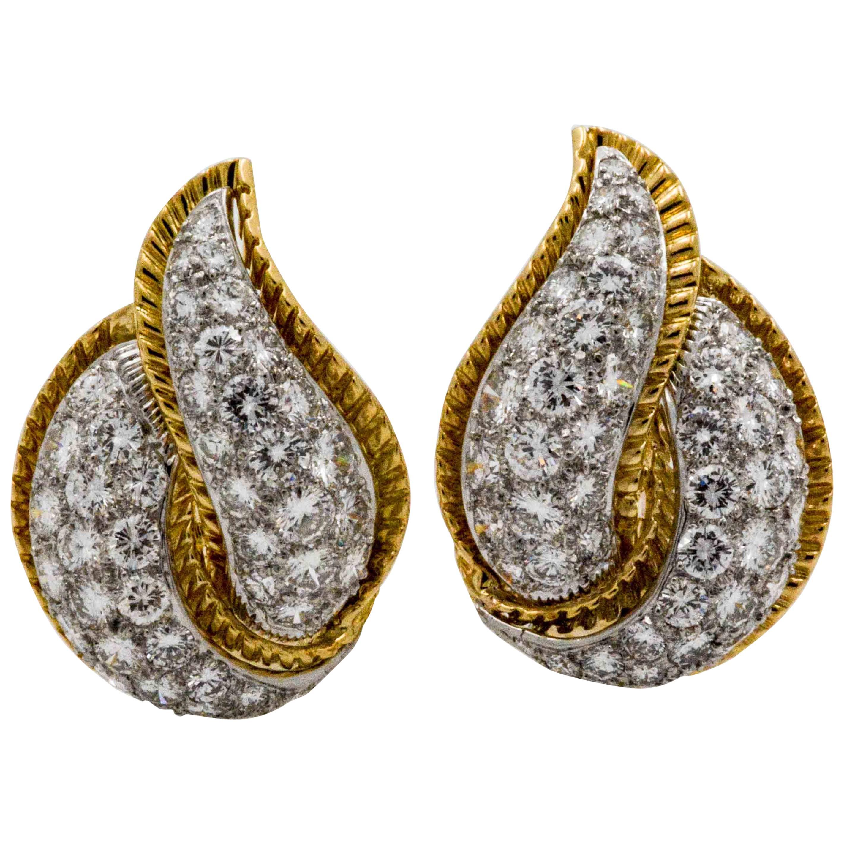 From the French designer, Modele Sterle, these circa 1970s earrings are decorated wtih 96 pave round brilliant cut diamonds, weighing a total of 5.25 carats. The diamonds are surrounded by a textured 18k yellow gold design, creating a leaf pattern.