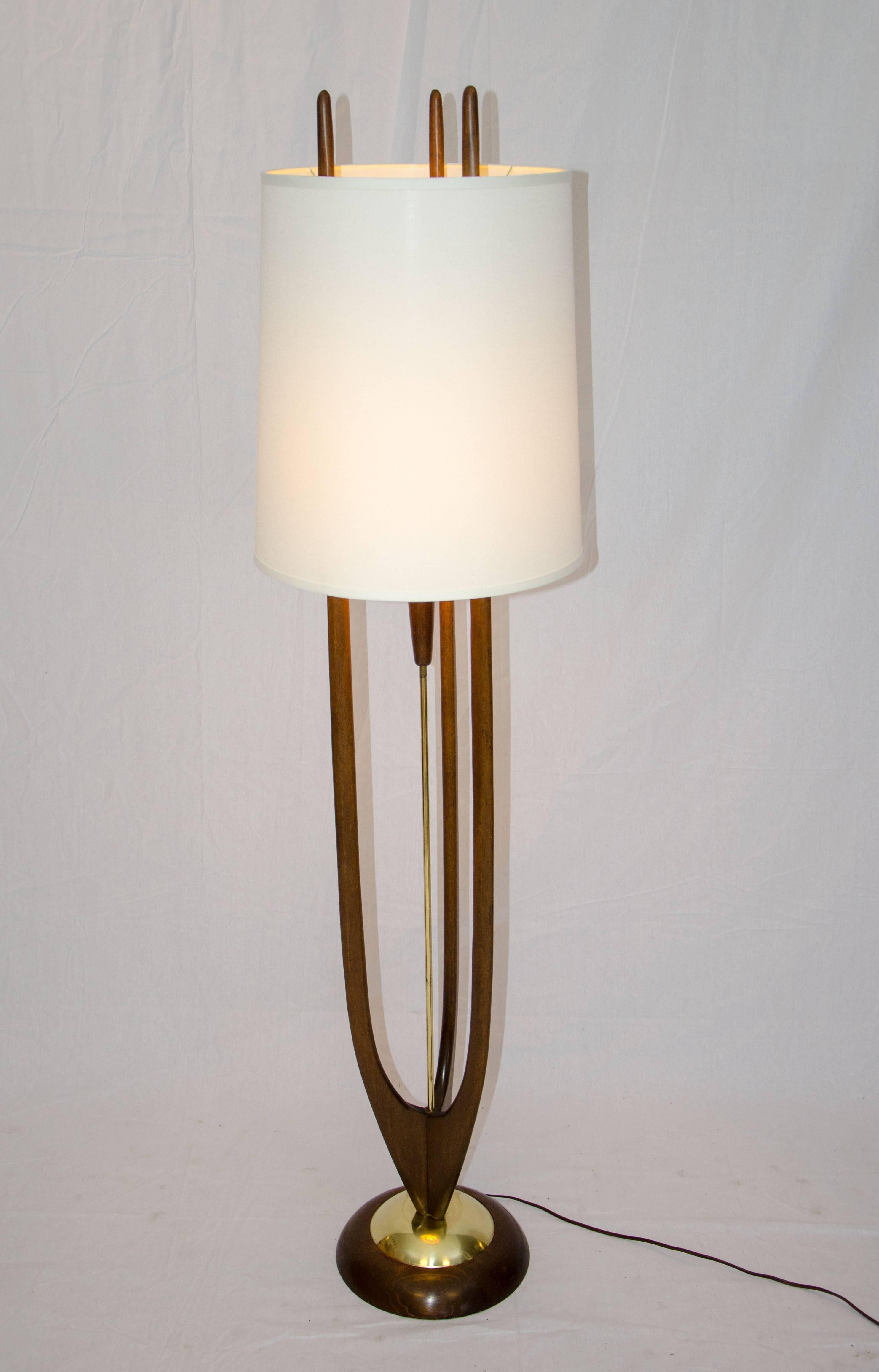 Very nice design floor lamp by the popular Modeline Lamp Co. The wood base is accented by a smaller brass circle. The center brass post holds the electrical cord; the original interior shade is positioned in the center of three walnut posts. The on