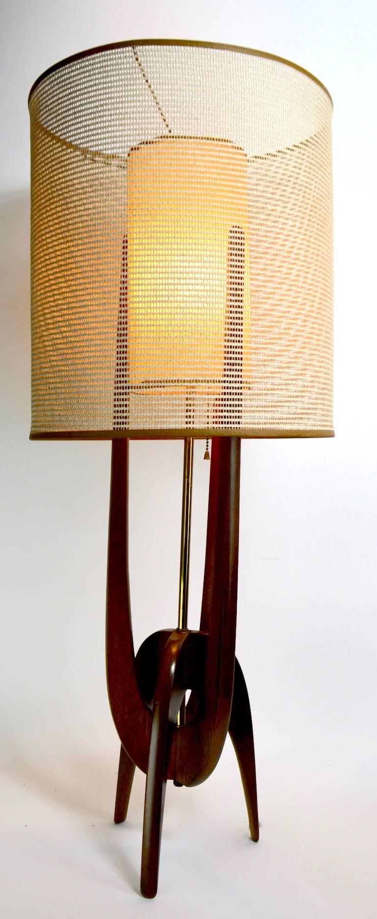 Classic midcentury lamp by Pearsall. This example is in very good, original, clean and working condition. It features the original weave outer shade and textured inner cylinder shade, on sculpted wood bass. Measure: Shade alone 14.75 diameter x