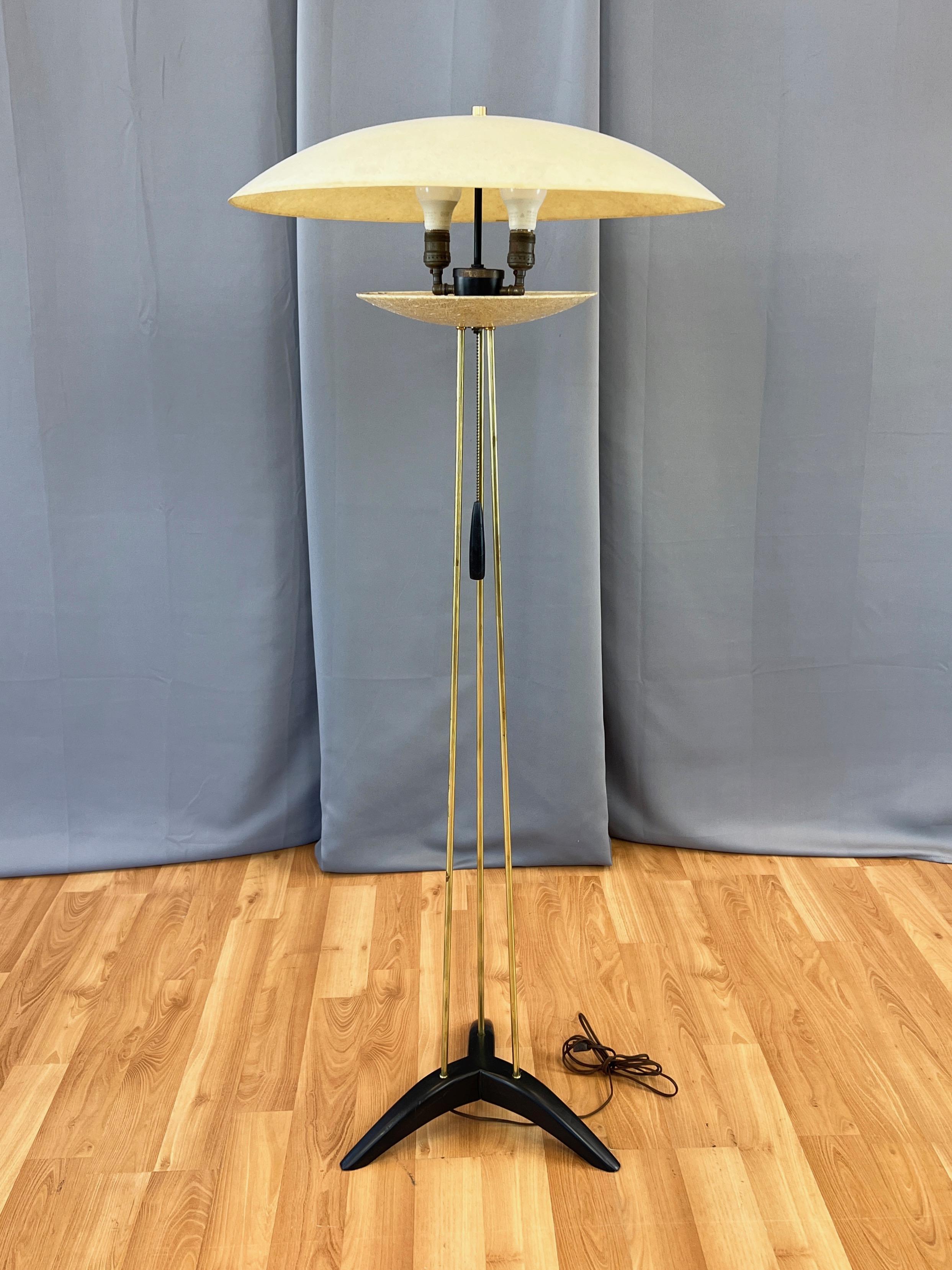 An exceptional and uncommon 1950s Modeline mid-century modern atomic-style tripod floor lamp with large fiberglass saucer shade and matching smaller one on a brass rod and black wood base.

Extra-large and impressive two-foot diameter cream-colored