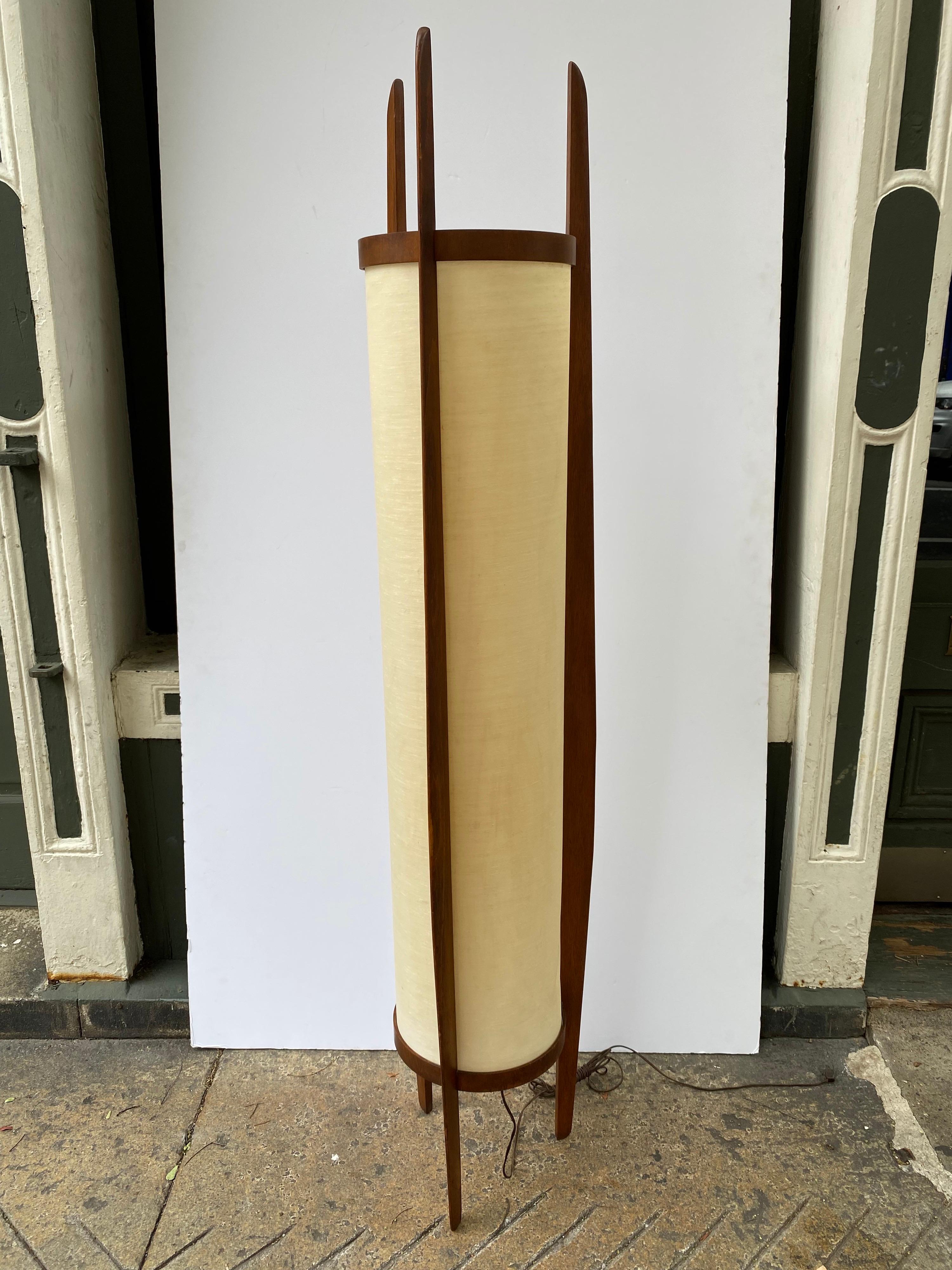 Very original Modeline floor lamp. 3 Walnut Legs support a cylinder lamp shade. Substantial size and scale. Switch that controls either top or bottom bulb or both! When turned on Shade looks great, when turned off there are several spots showing