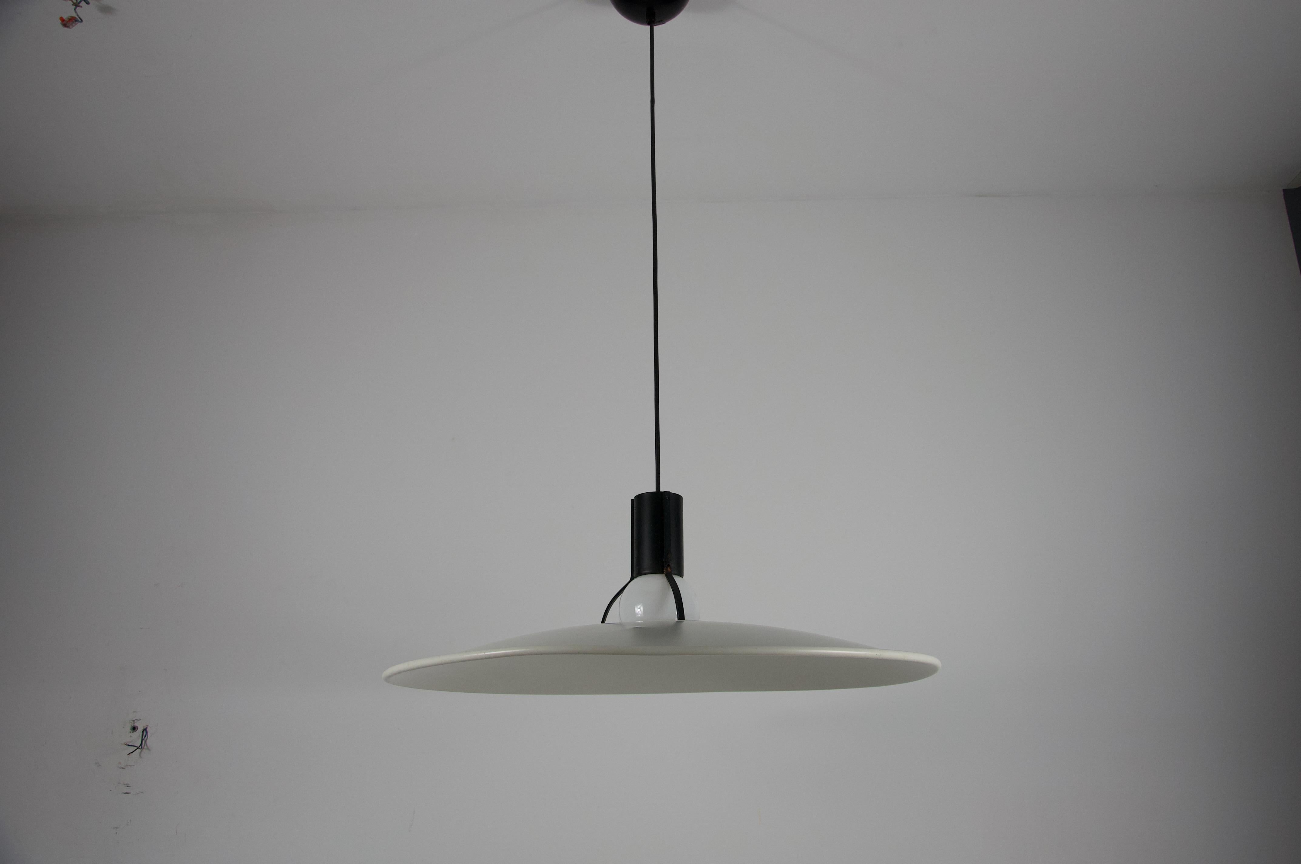This stunning Model 2133 pendant light duo by Gino Sarfatti for Arteluce (1972). It is a masterful study in minimalist design—a fluted white lacquered aluminum disc, suspended effortlessly from a sleek, fork‑shaped support in black lacquered steel.