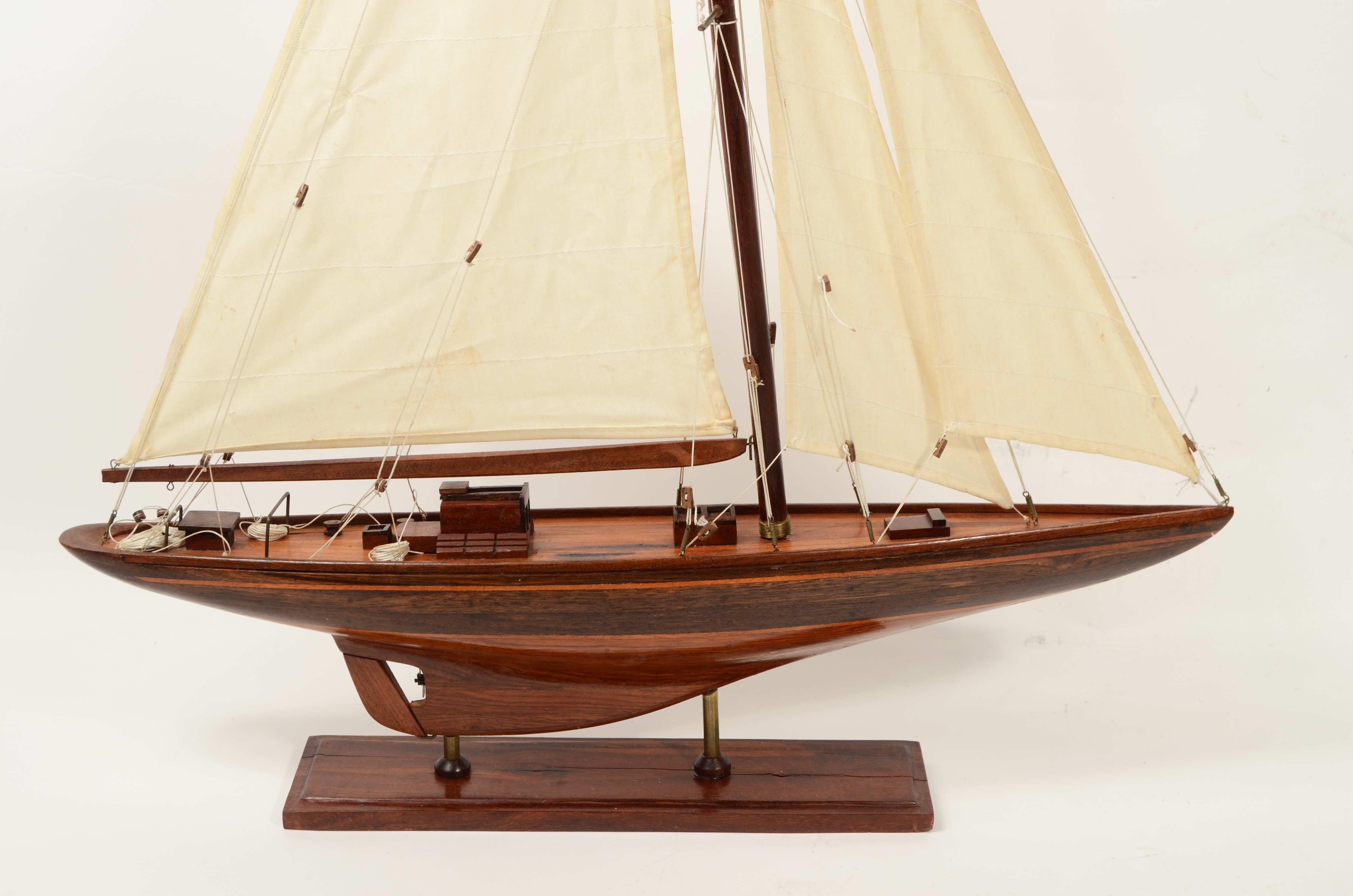 Élégante maquette de l'Endeavour, le célèbre yacht de classe J conçu par Charles Ernest Nicholson.
Fabriqué dans les années 1950 avec une coque en acajou, des garnitures en bois de cèdre et des voiles en coton, ce modèle reproduit fidèlement l'un