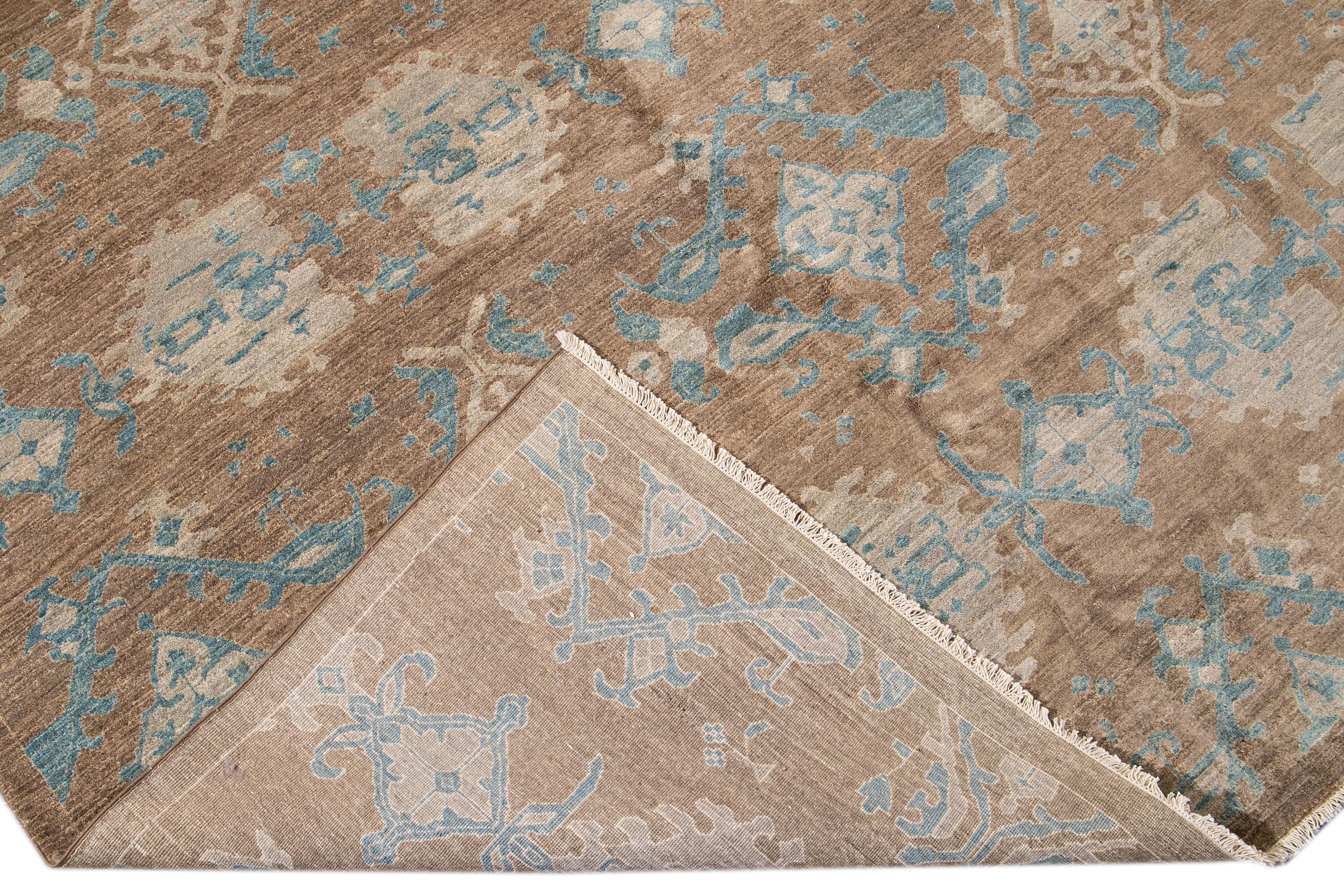 Beautiful modern oversize Persian Tabriz hand-knotted wool rug with a brown field. This Tabriz has accents of blue and beige in a gorgeous all-over geometric floral pattern design.

This rug measures: 12'1