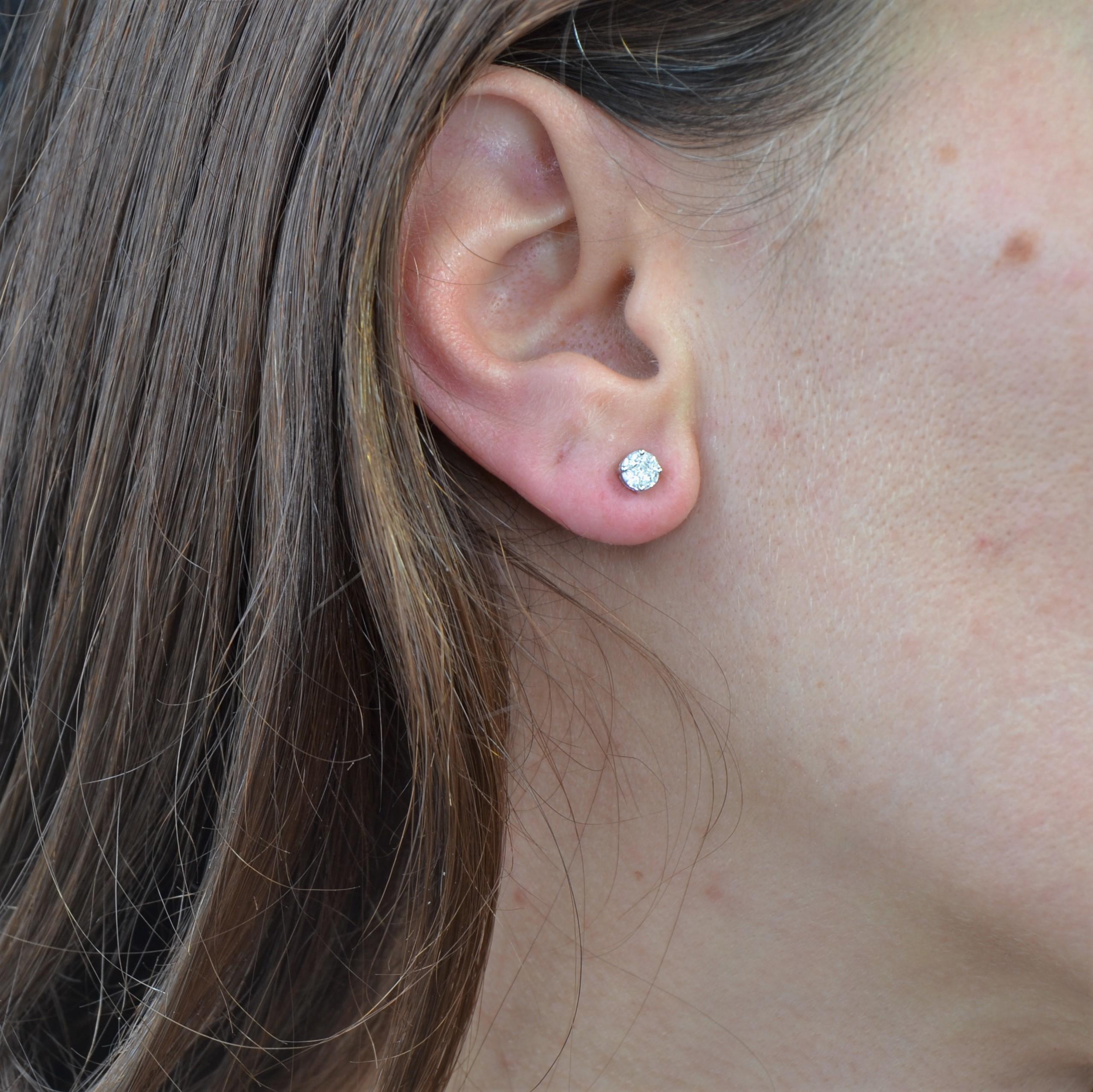 Für gepiercte Ohren.
Ohrringe aus 18 Karat Weißgold.
Diese dünnen Ohrringe aus Weißgold bestehen aus einem zentralen Diamanten im Prinzessinnenschliff, der von vier Navette-Diamanten umgeben ist, und sind mit Krallen besetzt. Der Verschluss dieser
