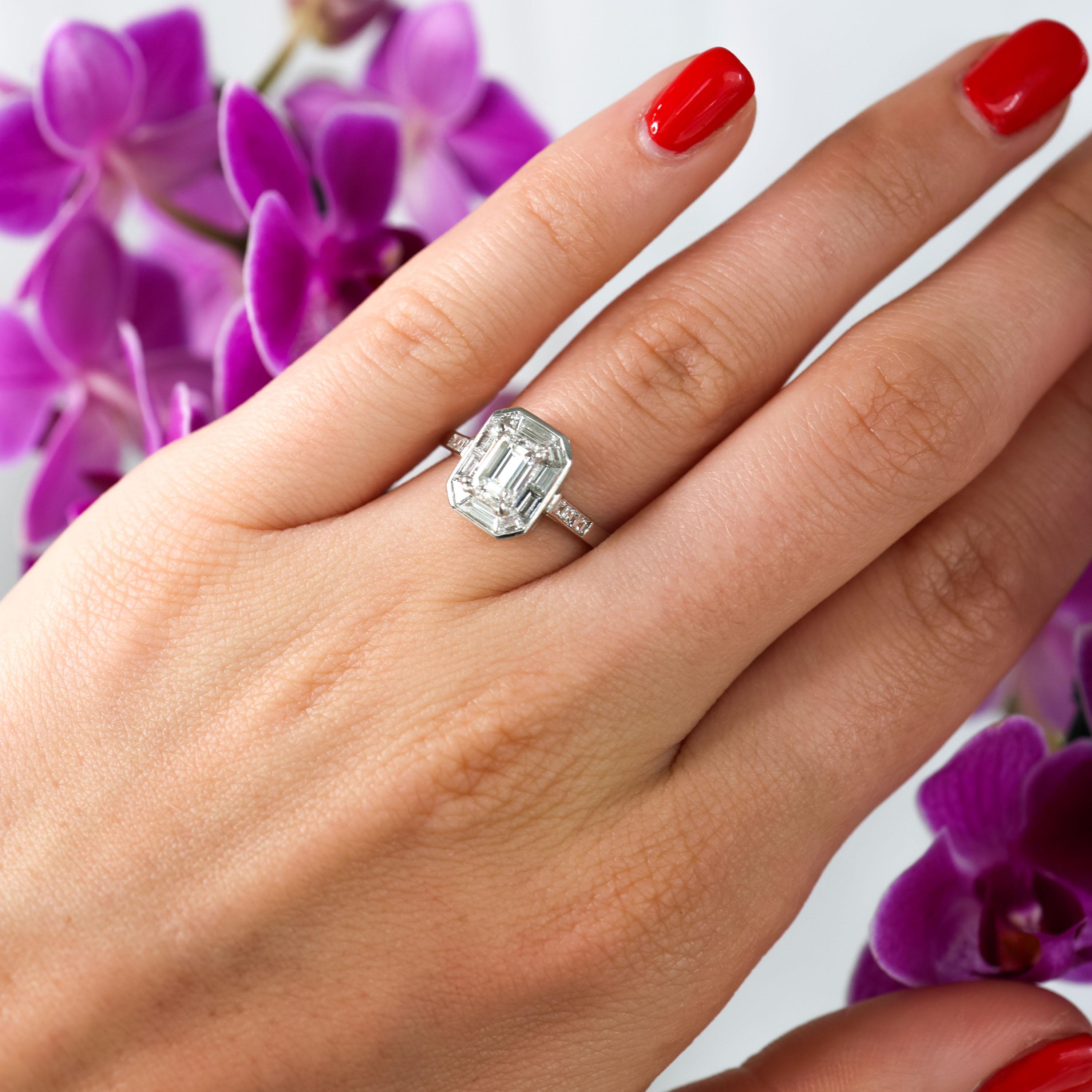 A modern diamond ring, centrally set with an emerald-cut diamond, weighing an estimated 0.72 carats, in claw a double four claw setting, with a surrounding border of mitre set baguette-cut diamonds, with a rub over edge, with three square-cut