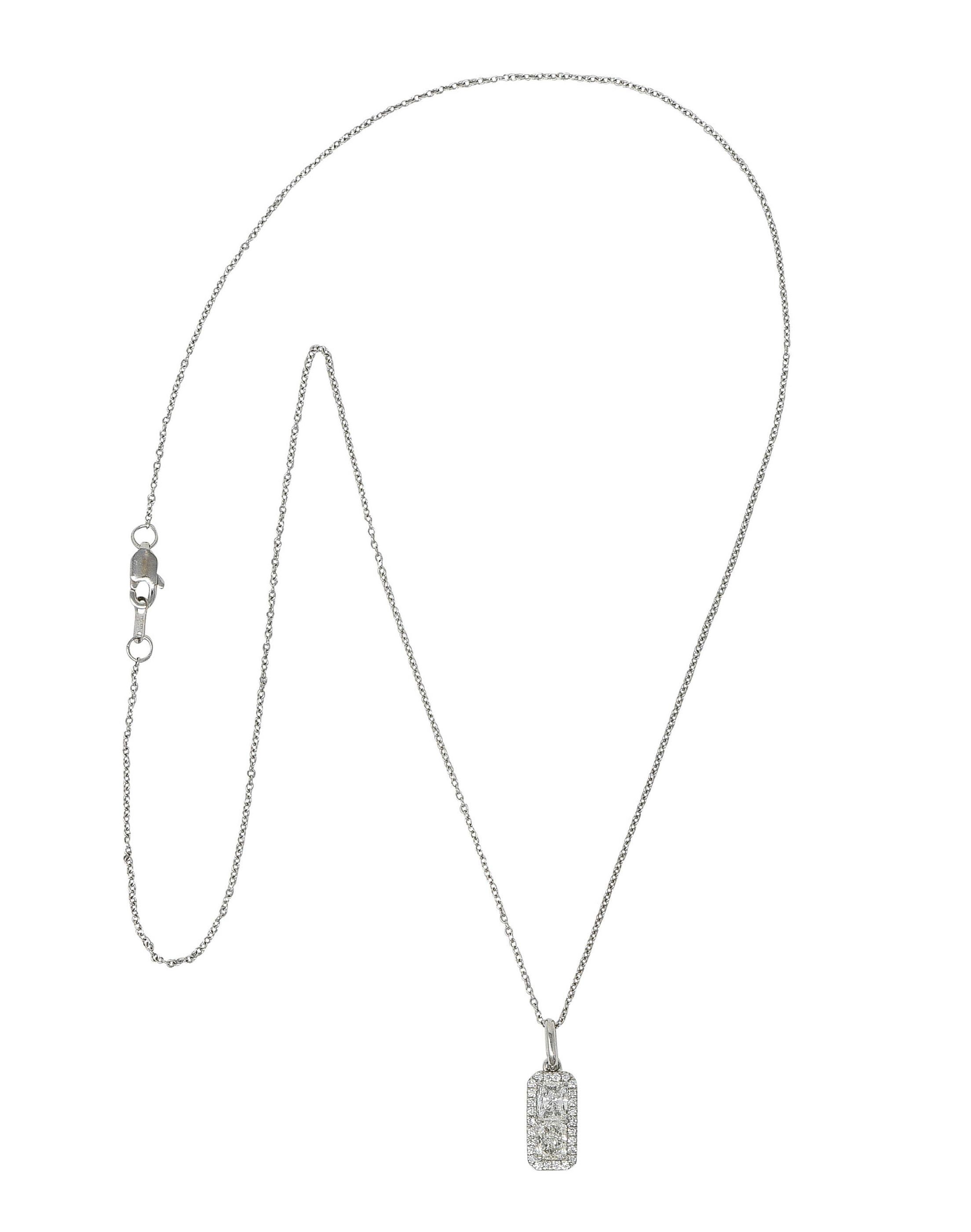 White gold classic cable chain necklace suspending a rectangular platinum pendant

Centering two radiant cut diamonds weighing in total approximately 0.70 carat - G color with VS clarity

Surrounded by a round brilliant cut diamond halo weighing in