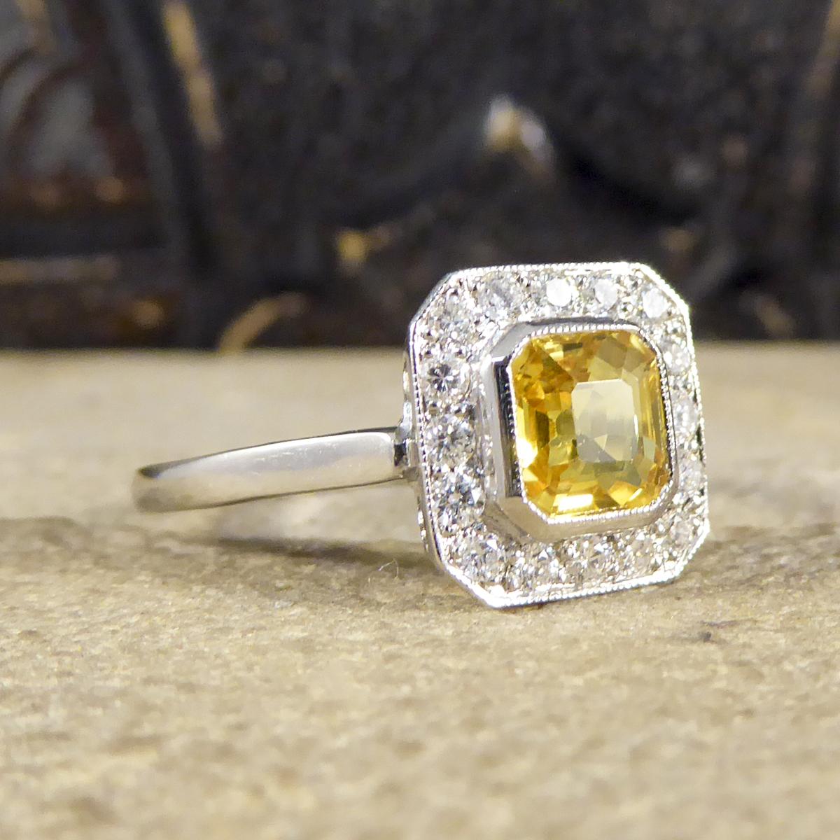 Dieser fabelhafte Clusterring von Contemporary glänzt an der Hand. In der Mitte befindet sich ein einzelner gelber Saphir im Asscher-Schliff mit einem Gewicht von 1,00ct, umgeben von insgesamt 0,25ct Diamanten im Brillantschliff. Der Ring ist in