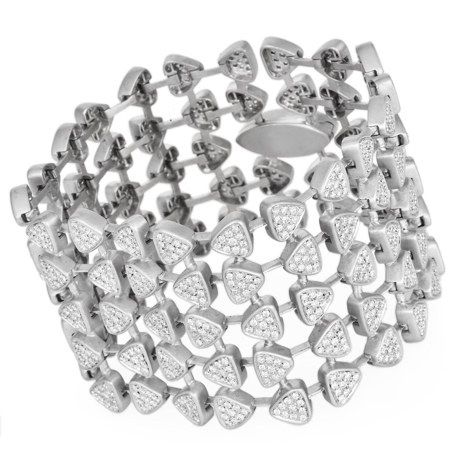 Esta pulsera ancha, de espectacular diseño contemporáneo, está fabricada en oro blanco de 18 quilates de suave acabado y compuesta por eslabones triangulares fluidos y articulados. Cada eslabón está engastado en pavé con diamantes redondos naturales