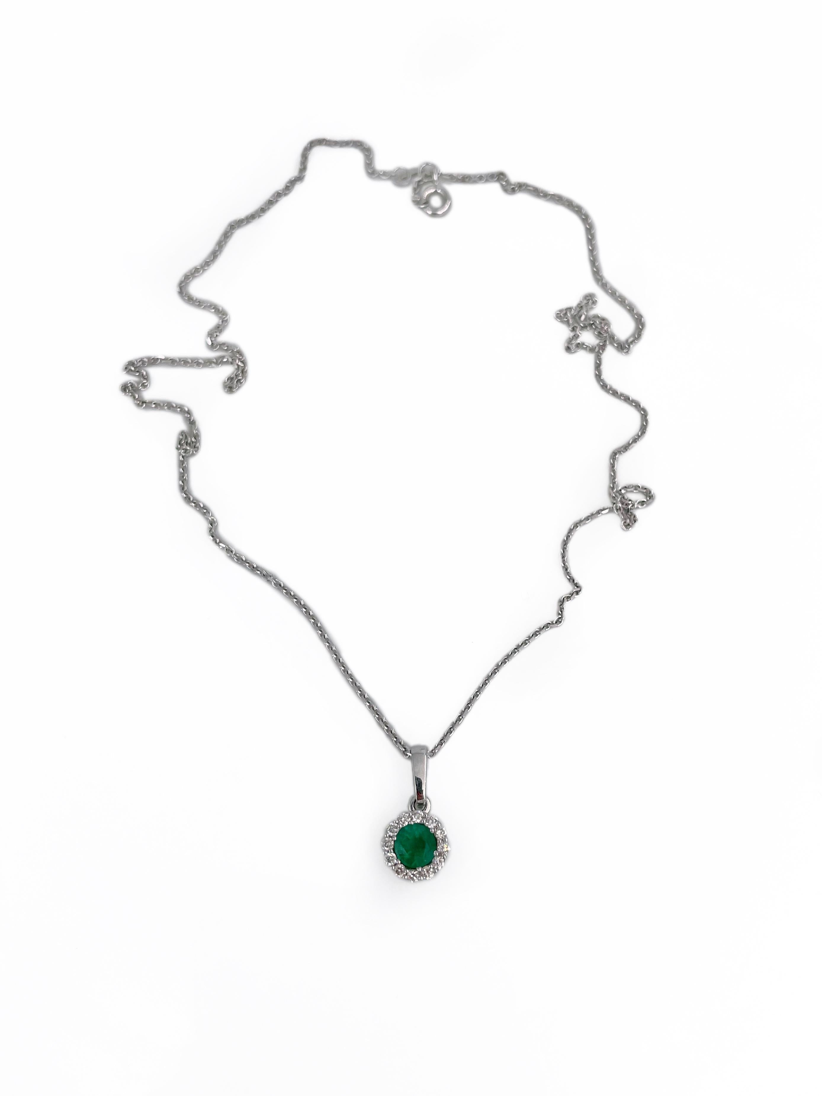 This is a modern pendant with a chain crafted in 14K white gold. Circa 2010.

The piece features:
- 1 emerald, round cut, 0.40ct, vslbG 5/4, P2
- 12 diamonds, round brilliant cut, TW 0.20ct, RW-W, VS

Weight: 3.59g (0.94g - pendant, 2.65g -