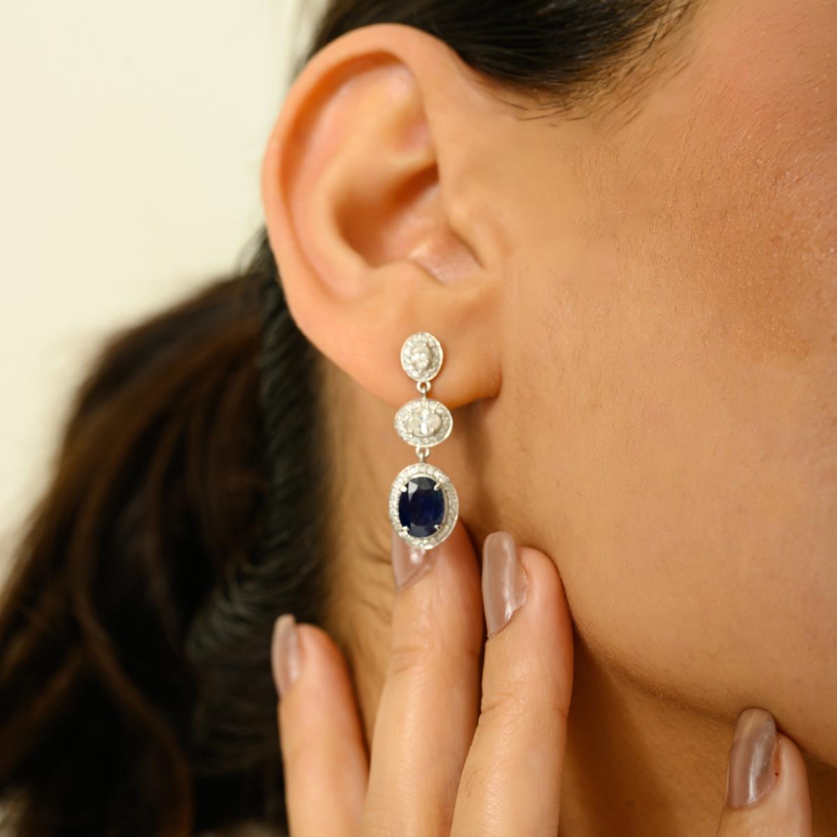 Eleganti e senza tempo, questi straordinari orecchini a goccia sono realizzati in oro bianco 14 carati. Caratterizzato da uno splendido trio di motivi ovali, il design mette in mostra affascinanti gemme di zaffiro blu per un totale di 2,96 carati,