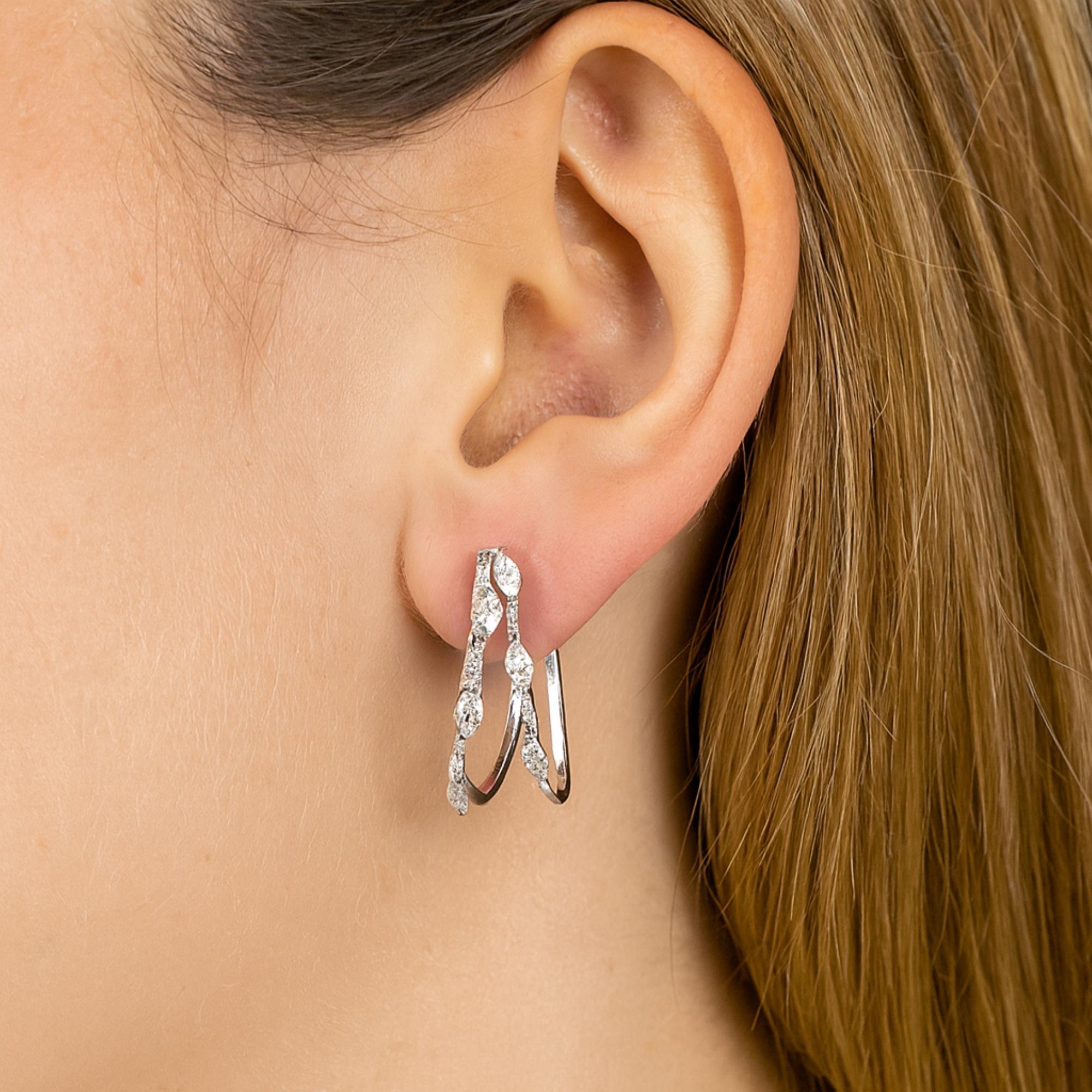 Moderne 14K White Gold Double Band SI Clarity HI Color Diamond Huggie Earrings Diese Ohrringe zeichnen sich durch eine moderne doppelte Ring-Silhouette aus, die die Illusion von zwei Schichten vermittelt, die anmutig am Ohr entlang schweben. Der