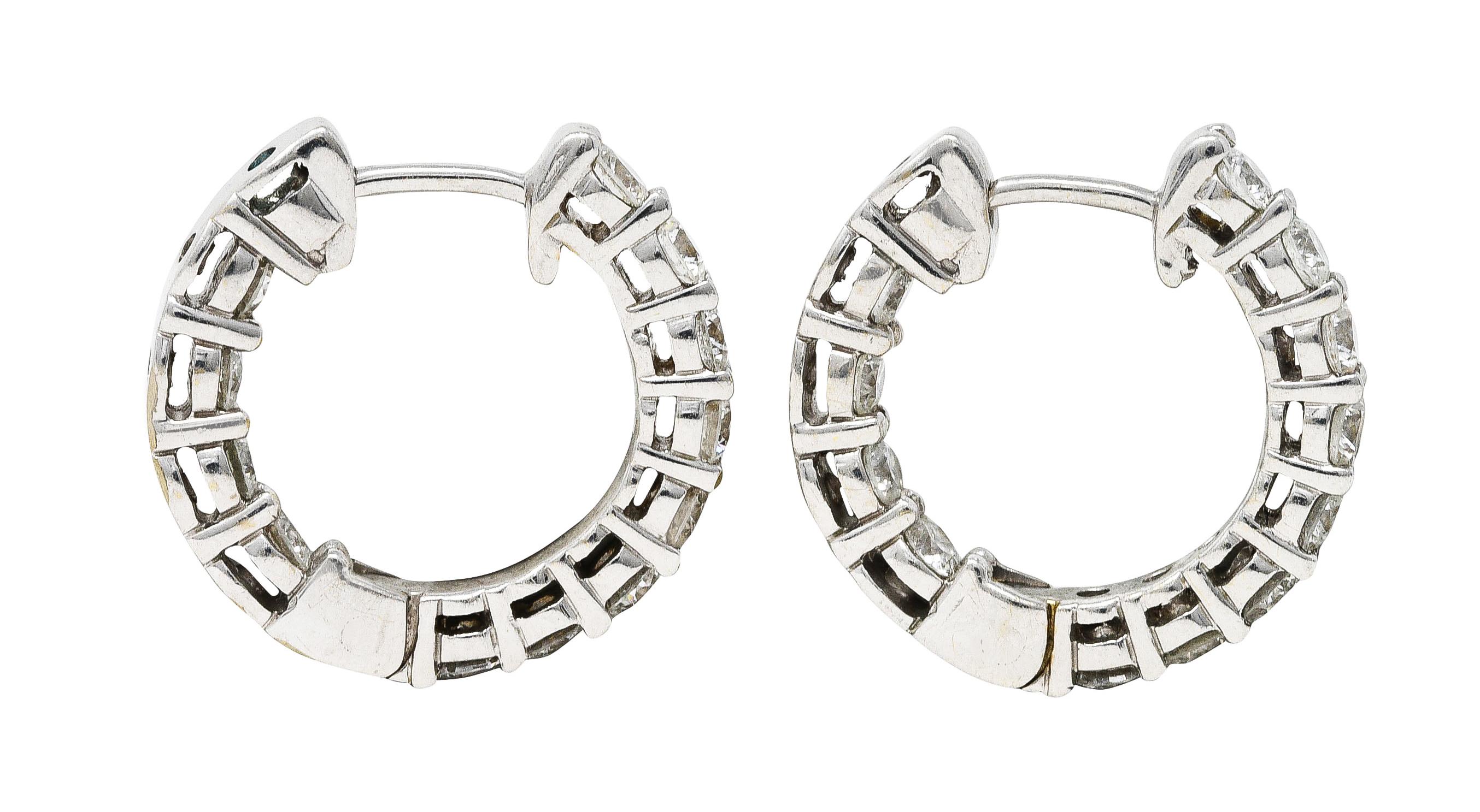 Inside/outside style huggie hoops

Featuring round brilliant cut diamonds via shared prongs

Weighing in total approximately 1.50 carats with G to H color and primarily SI clarity

Opens on a hinge and completes as posts

Tested as 18 karat