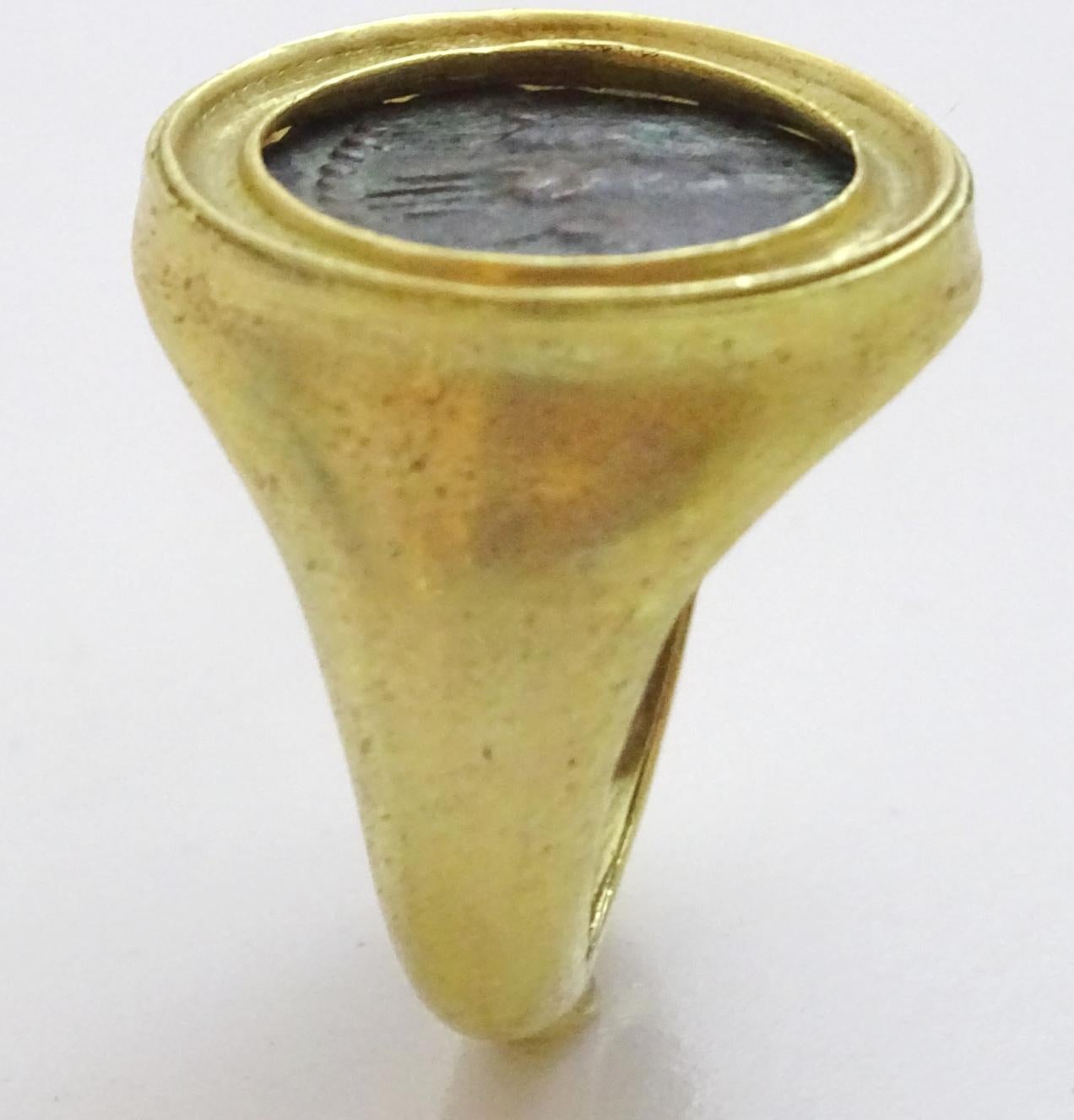 This is a ring from our workshop in Jerusalem. 
A  acid tested 18 k modern design that frames an authentic Bronze coin from the era of the rebellion of Bar Kochva in the first century AD.
The ring is size 9 and can be sized at no extra cost.

 