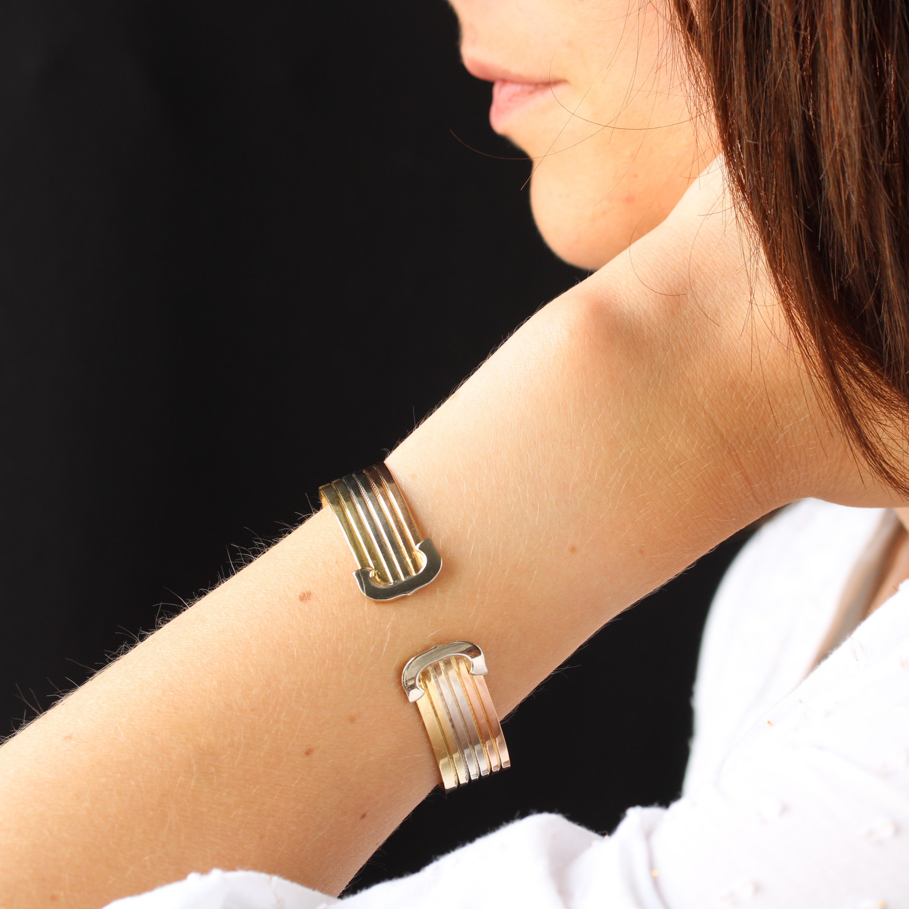Bracelet in 18 karat yellow, rose and white gold, eagle head hallmark.
Oval beaded bracelet, open at the base, made of 3x2 flat wires in 3 gold colors. It ends at the opening with 2 C-shaped motifs in white gold.
Height : 15,6 mm approximately,