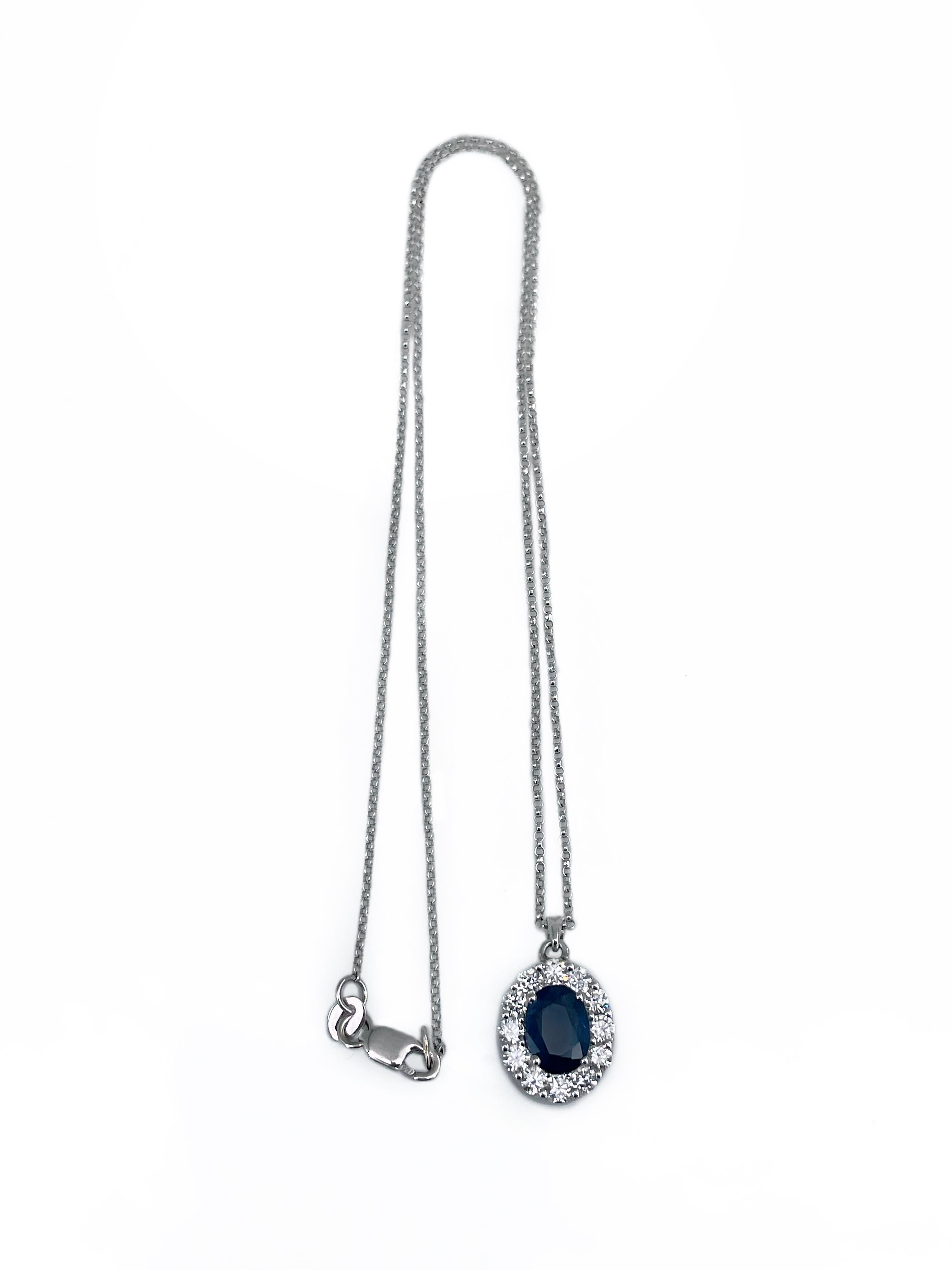 This is a modern design pendant with a chain crafted in 18K white gold. Circa 2000. 

The piece features:
- 1 sapphire (oval cut, 1.80ct, B 7/3, P2)
- 12 diamonds (round brilliant cut, TW 0.60ct, RW-W, VS-SI)

Weight: 4.33g
Pendant length: