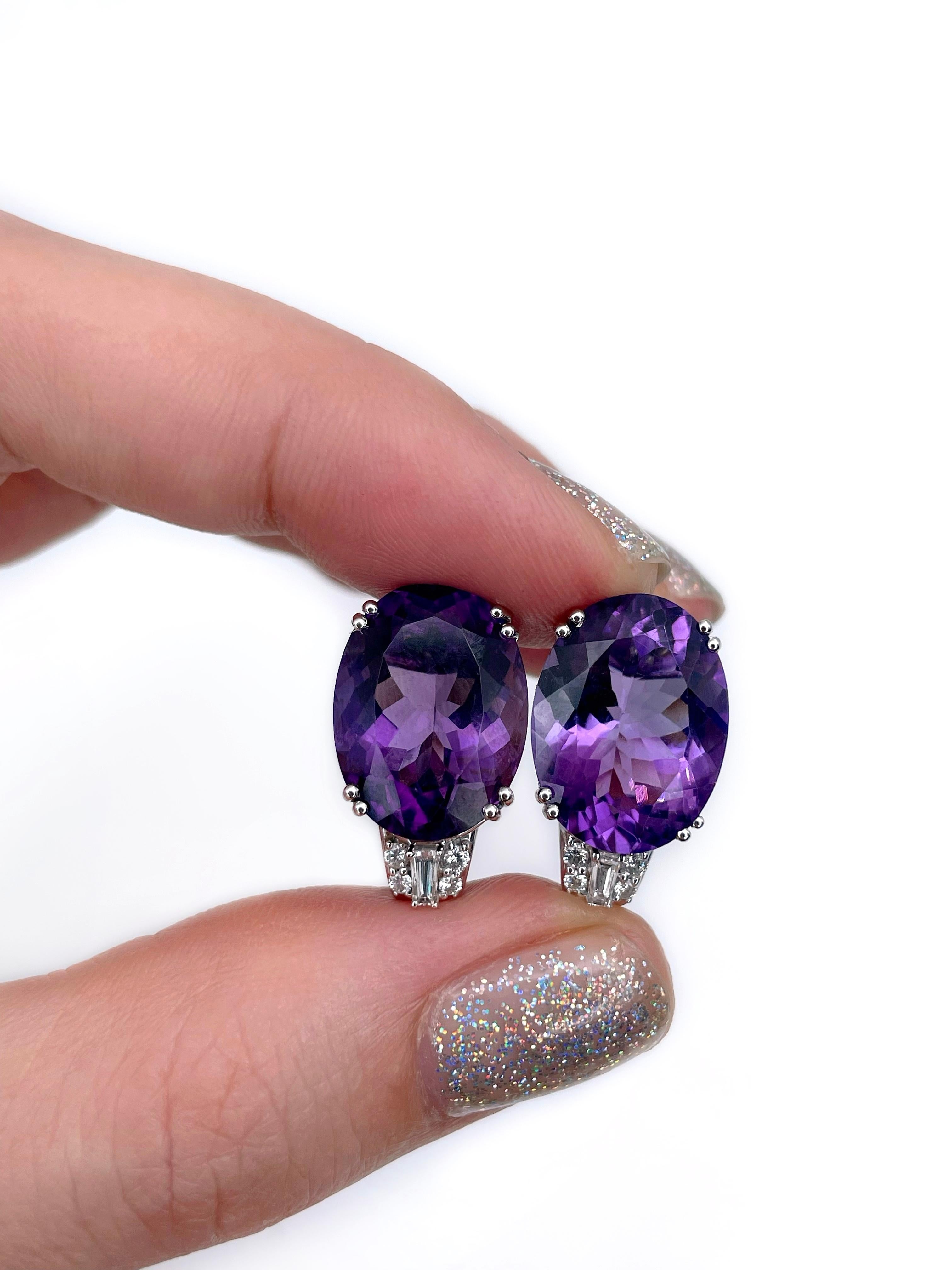 This is a stunning pair of stud earrings crafted in 18K white gold. The piece features 2 oval amethysts. The gems are paired with diamonds: 
- 8pcs., round brilliant cut, 0.11ct, RW-W, VS-SI
- 2pcs., trapeze cut, 0.10ct, RW-W, VS

Weight: 7.94g