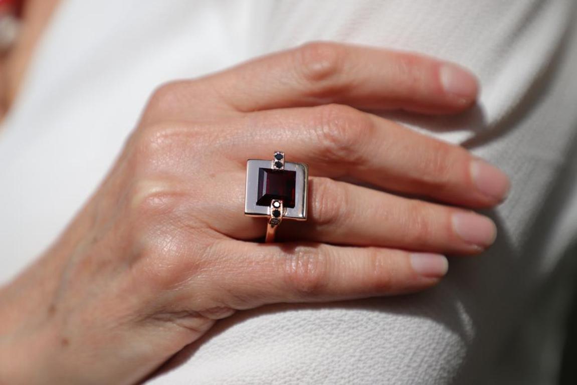 Elevate Your Style with Rossella Ugolini's Design Collection: A Modern 18 Karat Rose Gold Ring adorned with a mesmerizing Garnet and 0.20 Carats of Black Diamonds. This exquisite cocktail ring boasts a square-cut Garnet, elegantly cradled on a flat