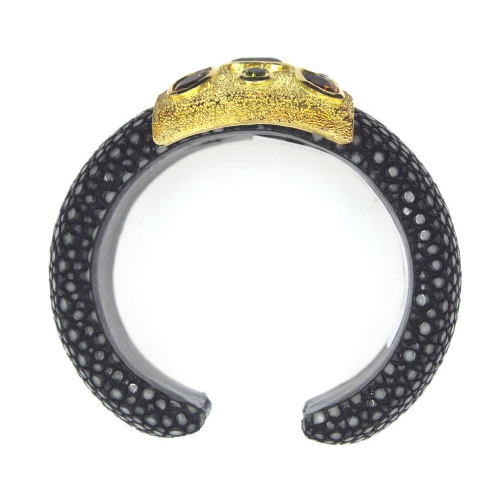 Fabulous modern estate cuff bracelet fashioned in 18 karat yellow gold and stingray leather. The wide cuff measures 1.25 inches in width and will fit a 6-7