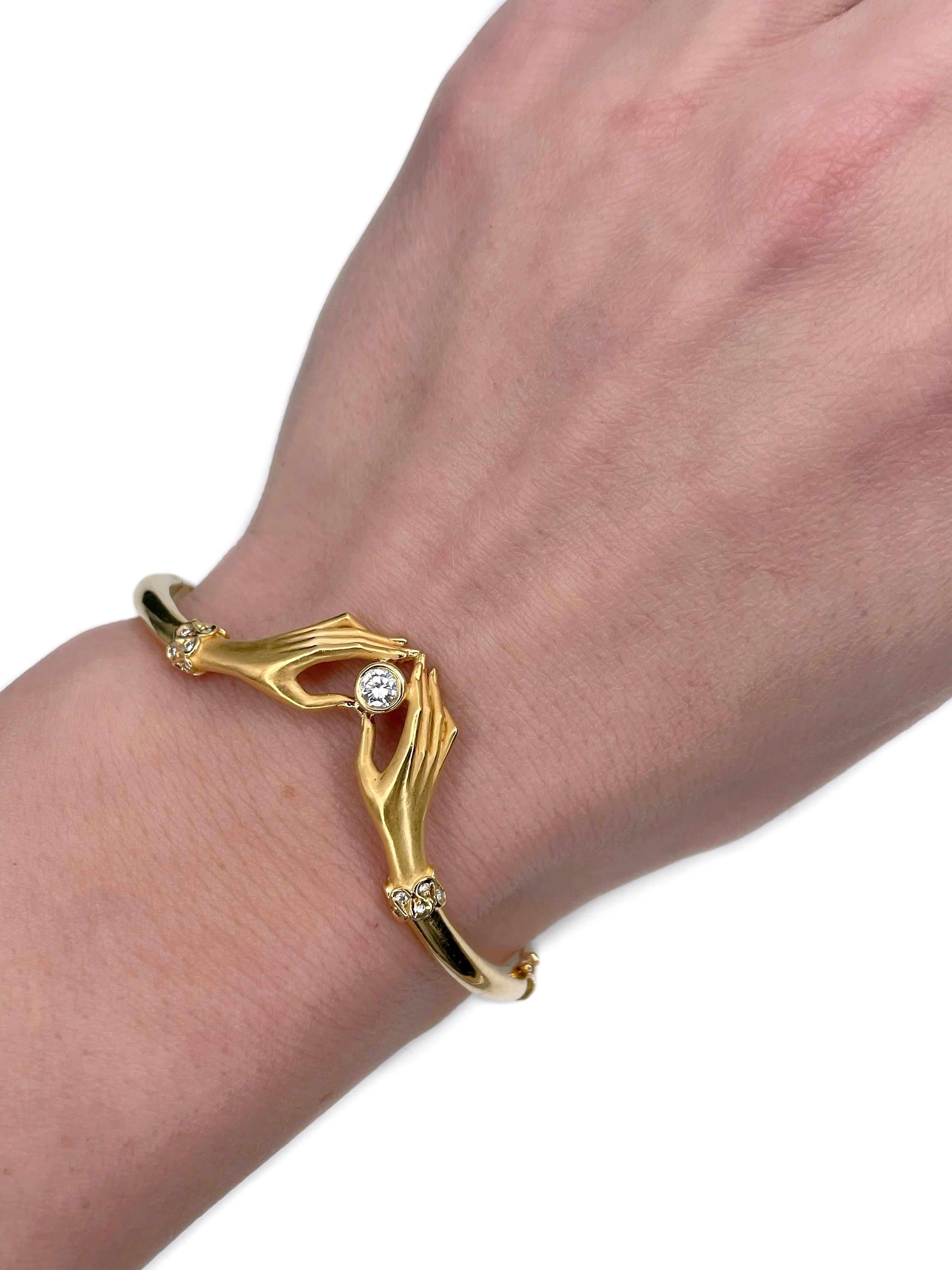 This is an elegant hinged bangle bracelet designed by Spanish jewellery brand “Carrera Y Carrera” in 2000s. It is crafted in 18K yellow gold. The piece depicts two hands holding a diamond.

There are hallmarks and serial number (shown in photo