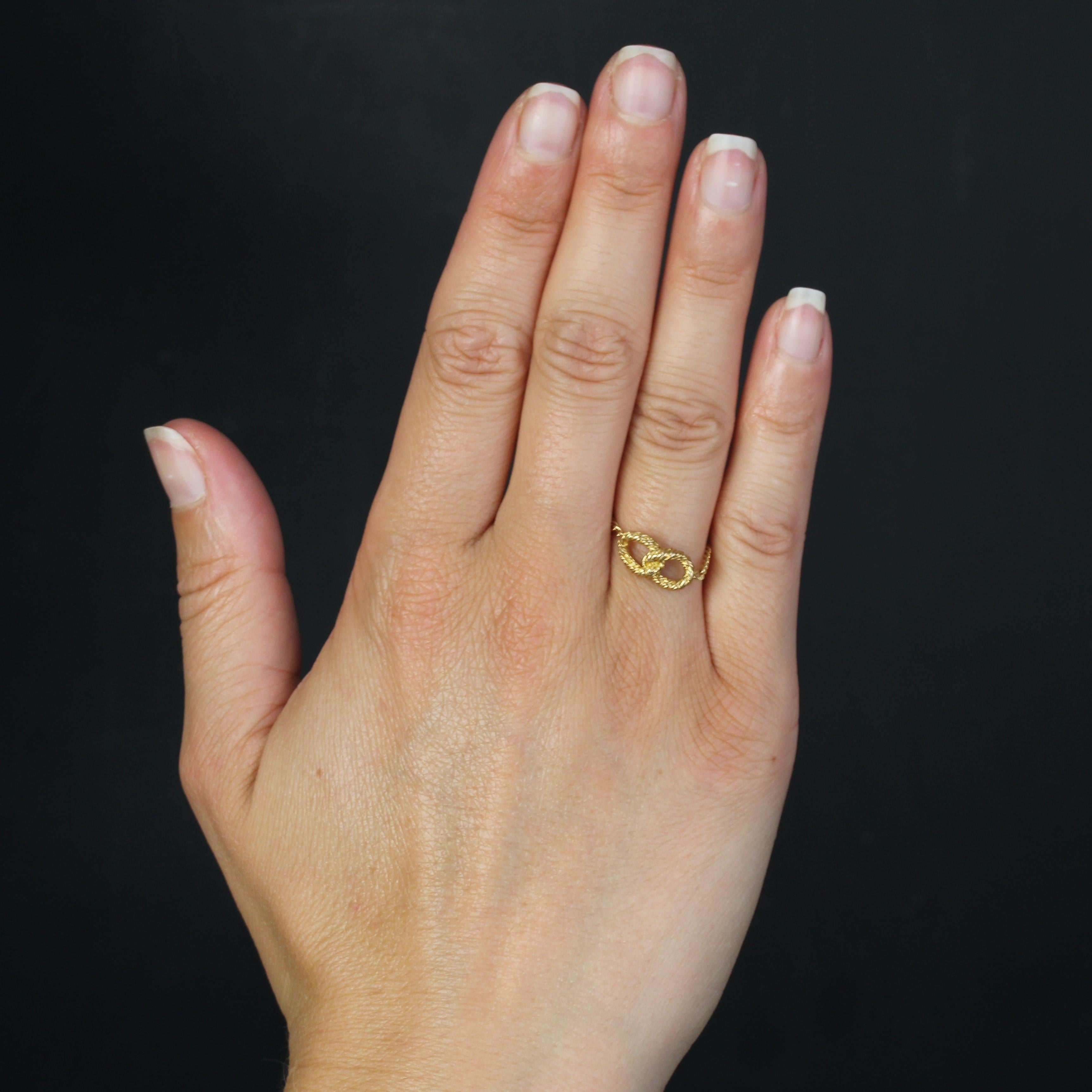 Bague en or jaune 18 carats.
Bague en chaîne en or jaune présentant une gourmette avec deux boucles entrelacées soudées en or jaune torsadé.
Hauteur : 6,5 mm environ, largeur : 13,5 mm environ, épaisseur : 4 mm environ, largeur de la chaîne : 1,7 mm