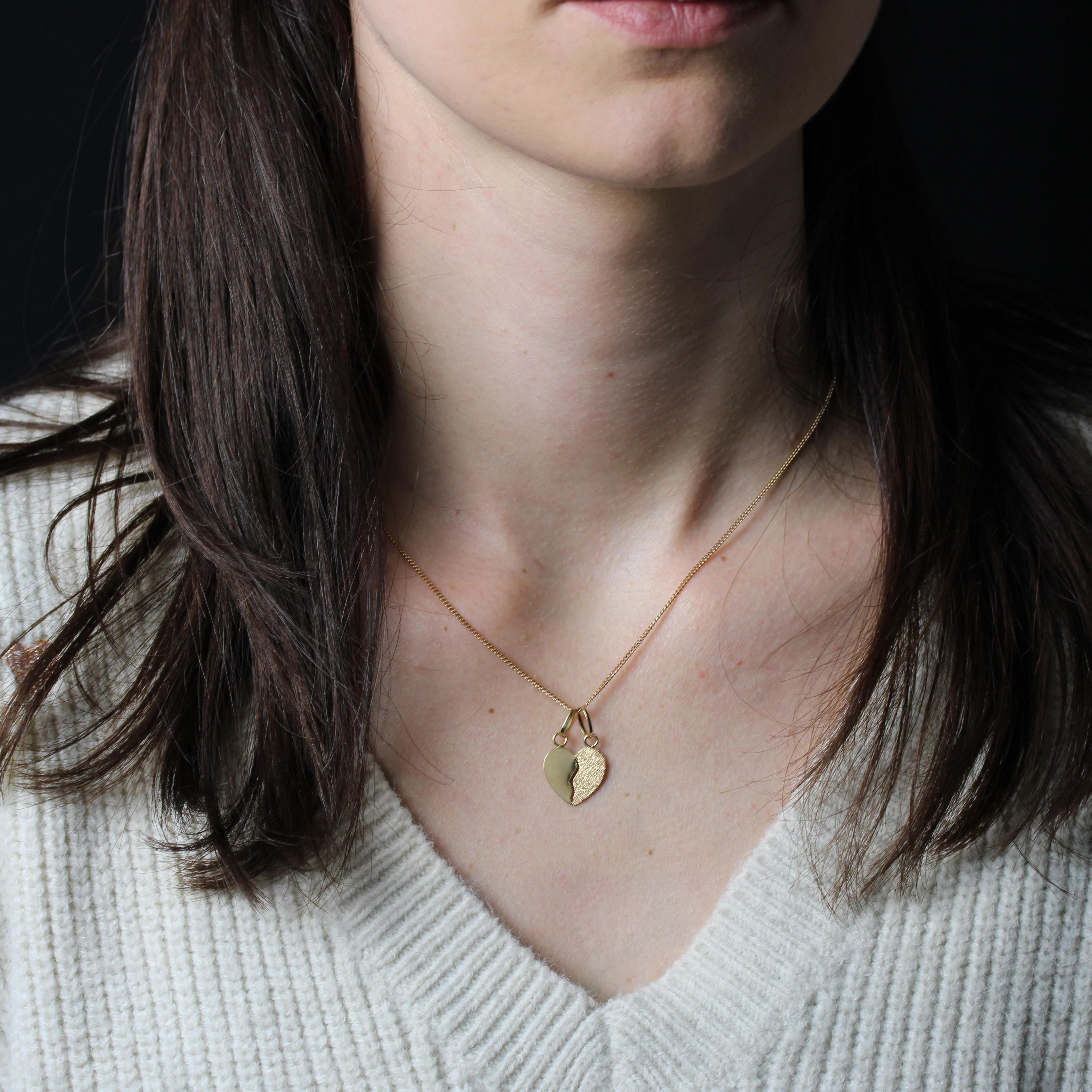 Chaîne en or jaune 18 carats, poinçon tête d'aigle.
Pendentif en forme de cœur plat avec une ligne brisée ajourée en son centre. Un côté du cœur est en or lisse et l'autre en or ciselé de lignes pointillées, inversé au dos. Chaque pièce est