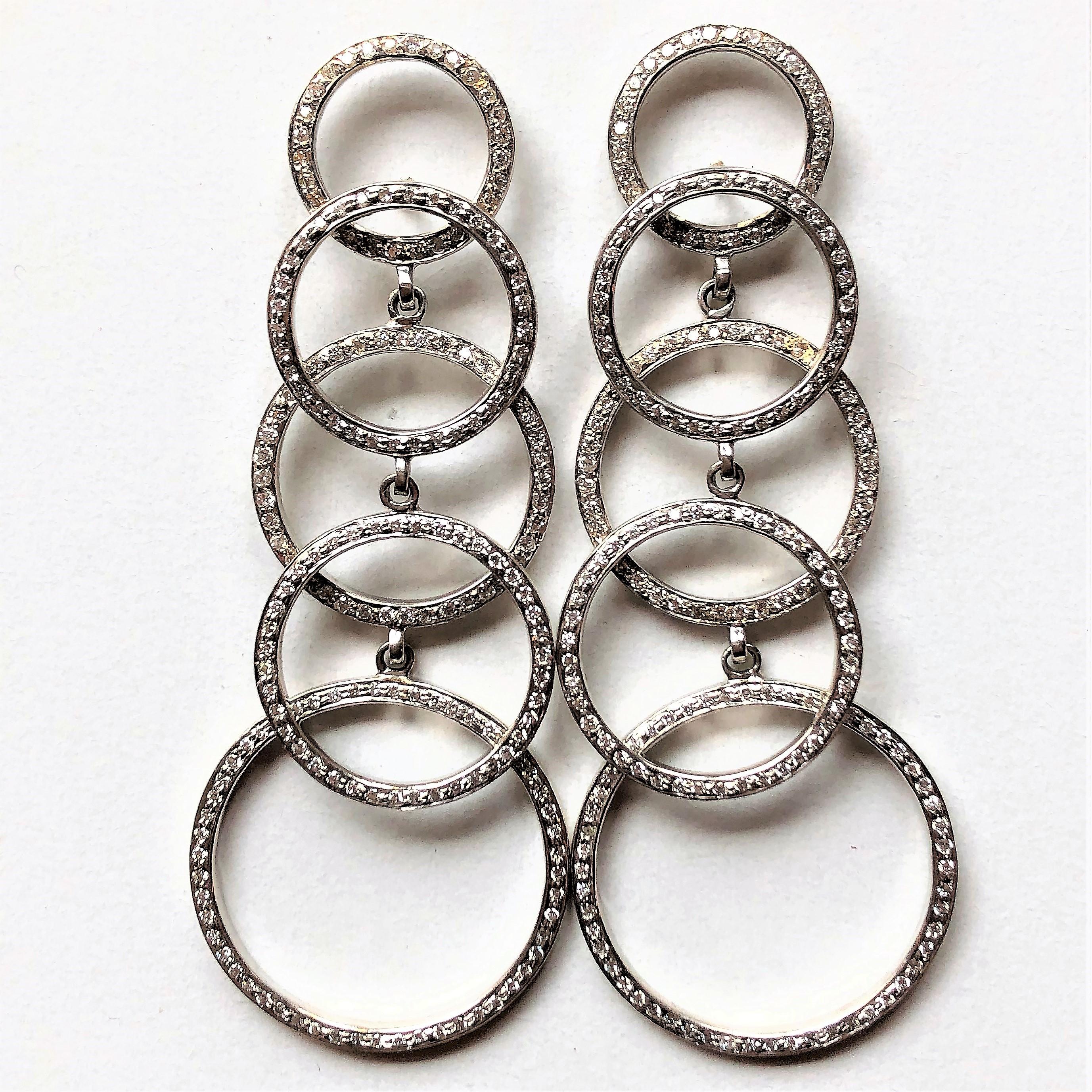 Gracefully cascading, these contemporary, 18K White Gold earrings are set with  round diamonds weighing approximately 3.75ct total.  Measuring just over 2 3/4 inch long
(2  13/16 inch) by 1 1/16 inch at the widest circle on the bottom. They are