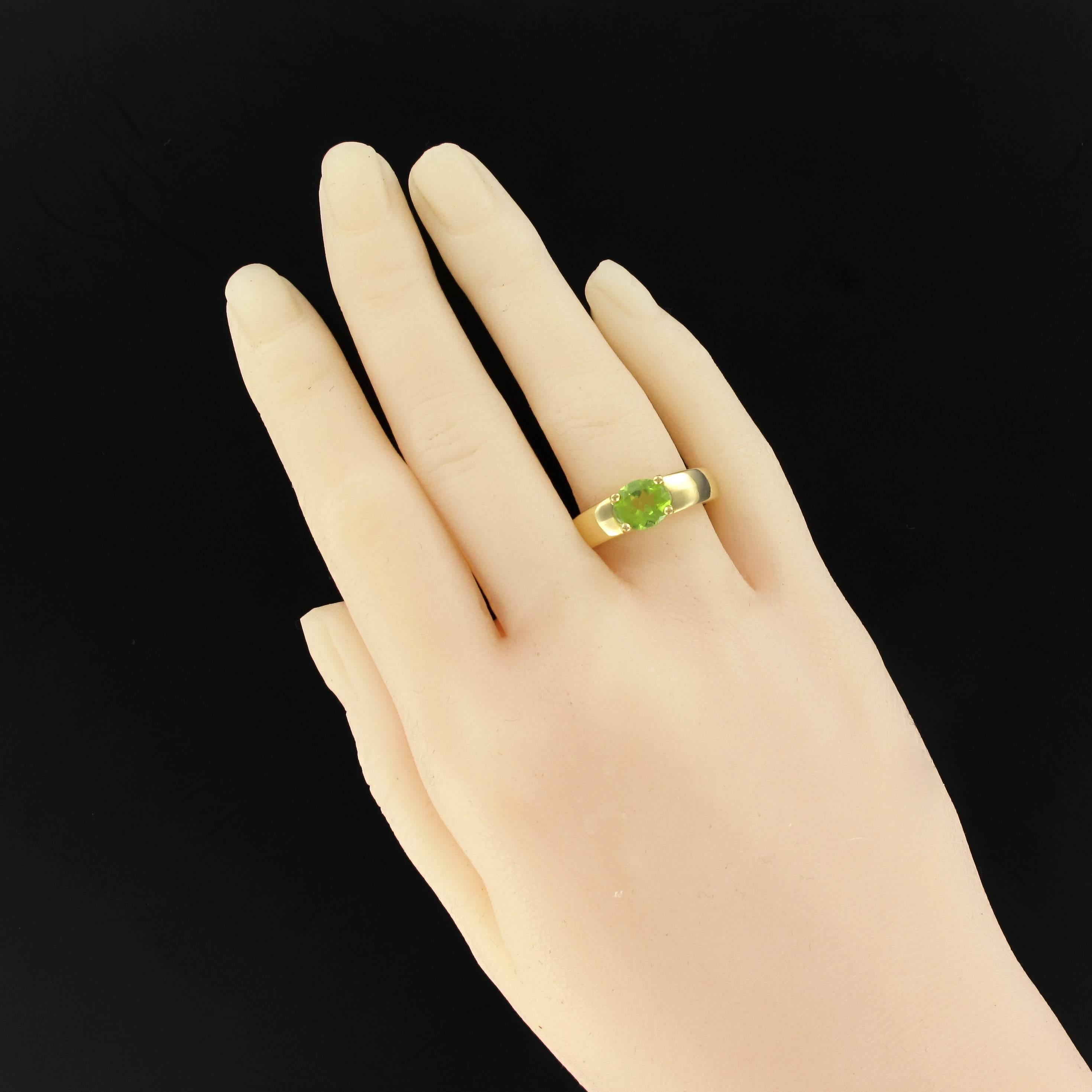 Ring in 18 karats yellow gold, eagle's head hallmark.
Bangle ring, it is set with 4 claws on the top of a faceted oval peridot.
Total weight peridot: about 1.30 carat.
Length: 6.8 mm, Width: 7.7 mm, Height: 6 mm, Width of the ring: 4.7 mm.
Total
