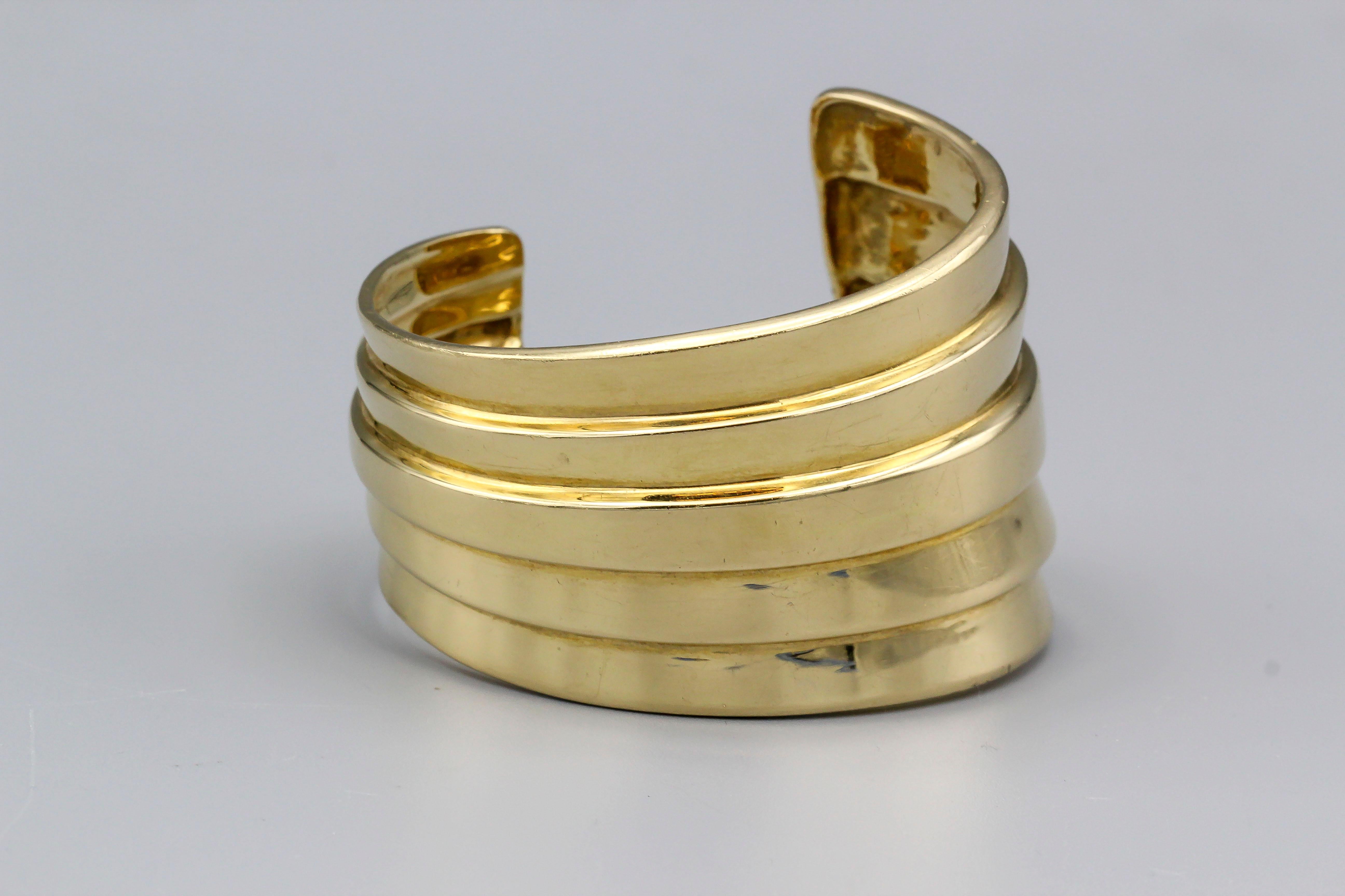 Fine 18k yellow gold cuff of an abstract/modern design.  The cuff bear a (C) and 18k mark, perhaps attributable to Angela Cummings.  Weight over 108 grams and almost 2 inches at its widest point, the cuff certainly offers a strong presence.  Made