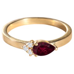 Moderner Ring aus 18 Karat Gelbgold mit einem Rubin im Birnenschliff und 3 runden Diamanten