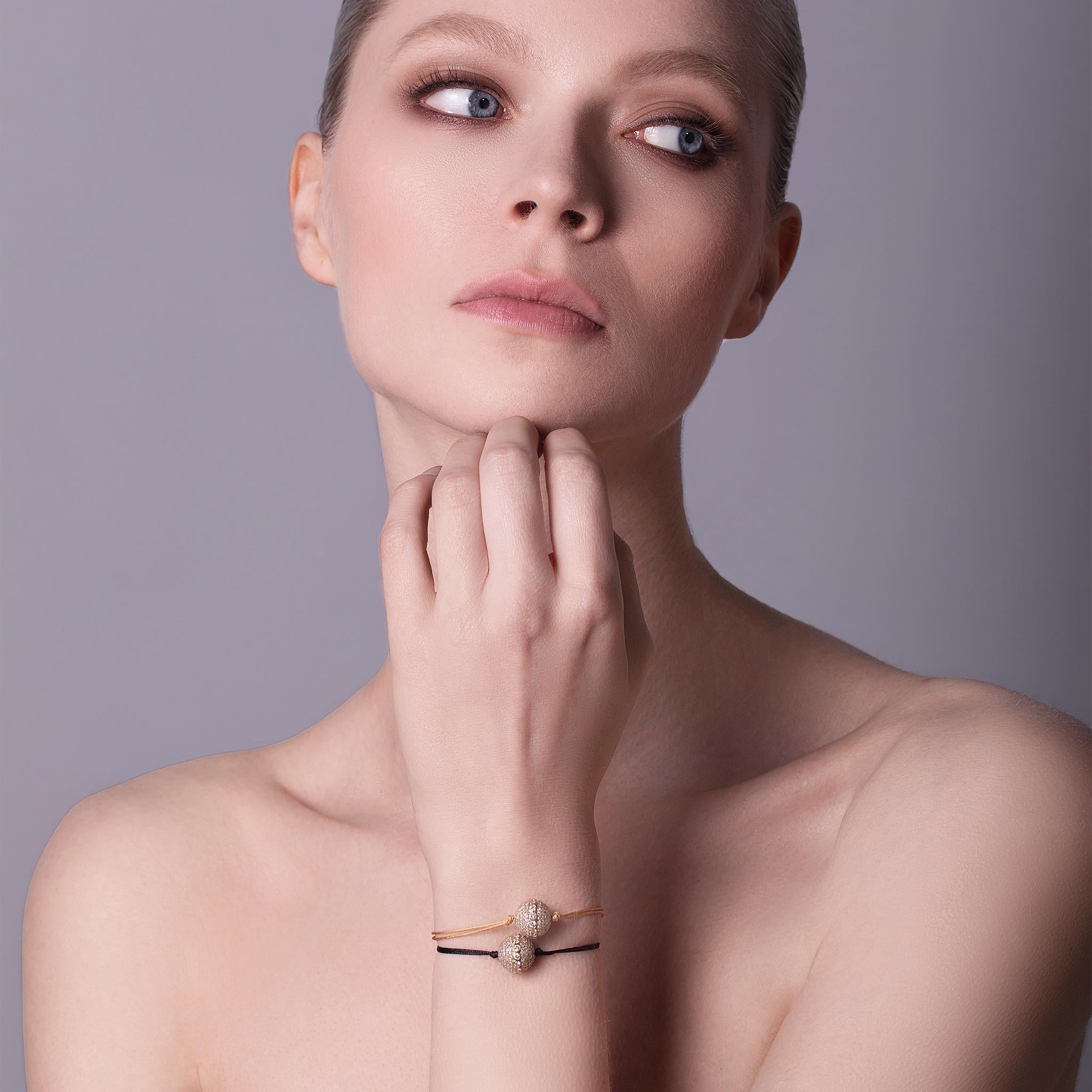 Una nueva versión de la clásica pulsera de talla única que representa el orbe infinito Signature de oro de 18 quilates de giro libre hecho a mano de THEVAULT15. Un Orbe especial con incrustaciones de brillantes diamantes y un cinturón de diamantes