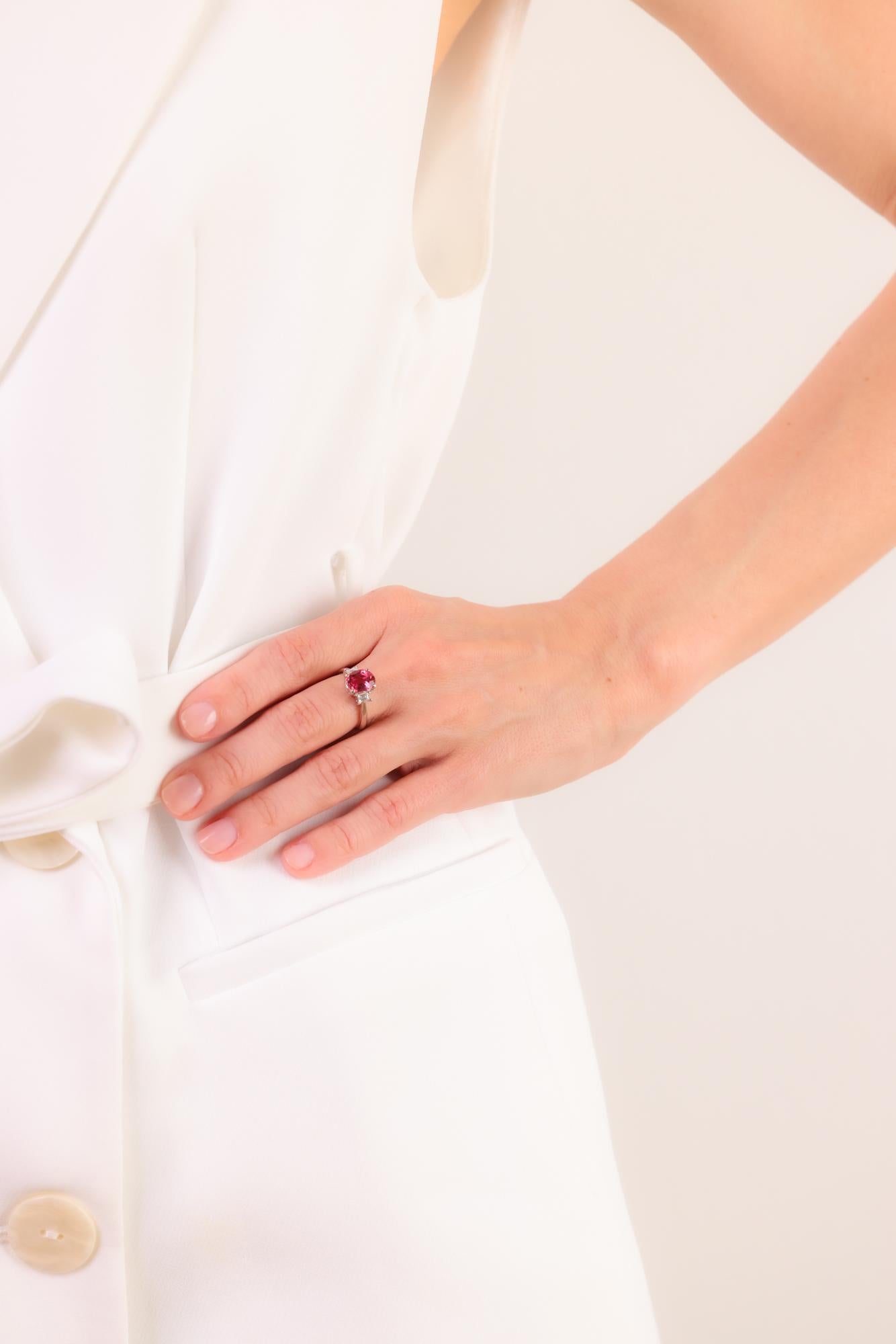 This modern platinum ring highlights a vibrant 1.93 carat pink tourmaline, complemented by sparkling emerald cut diamonds for an elegant, contemporary design.

Center stone: Oval cut pink tourmaline 
Weight: 1.93 carat
Accent stone: 2 emerald cut