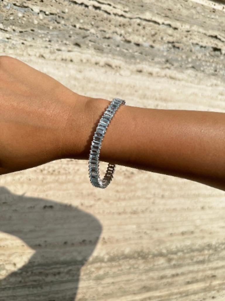 Le bracelet de tennis moderne 19.45 CTW Aquamarine en argent sterling met en valeur une aigue-marine naturelle d'un poids de 19.45 carats, étincelante à l'infini. Il mesure 7.25 pouces de long. 
L'aigue-marine stimule la concentration et réduit le