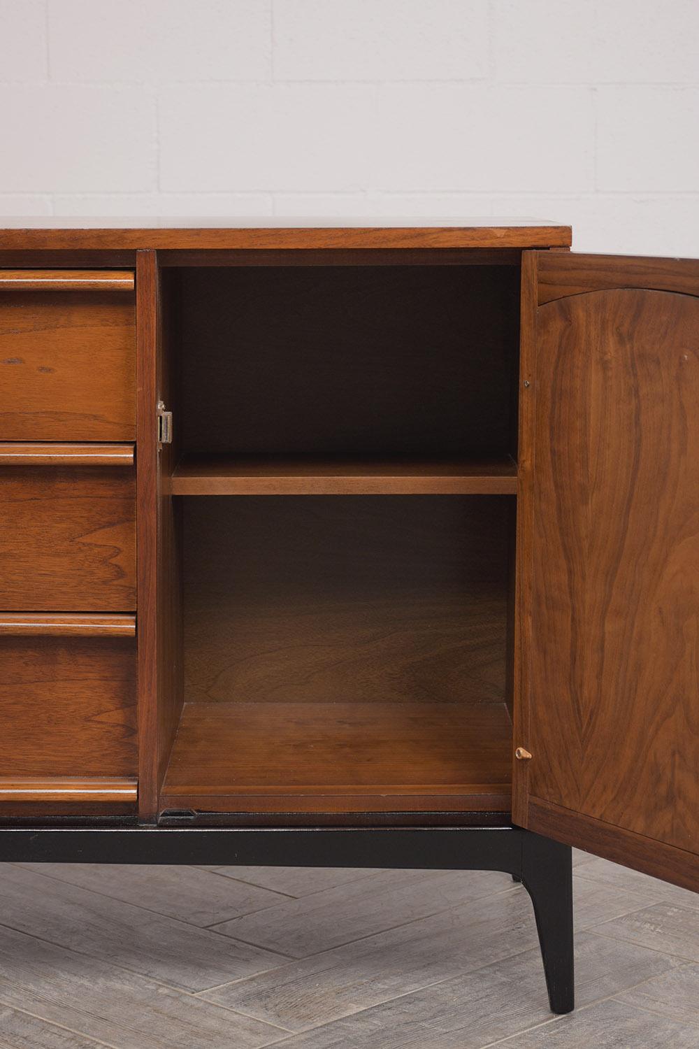Beautiful 1960s modern walnut credenza, its been stained in a rich walnut and black color combination with lacquer finish. Comes with two doors decorated with a cane panel on each side of the piece, combined with 3 long drawers ,resting on stylish