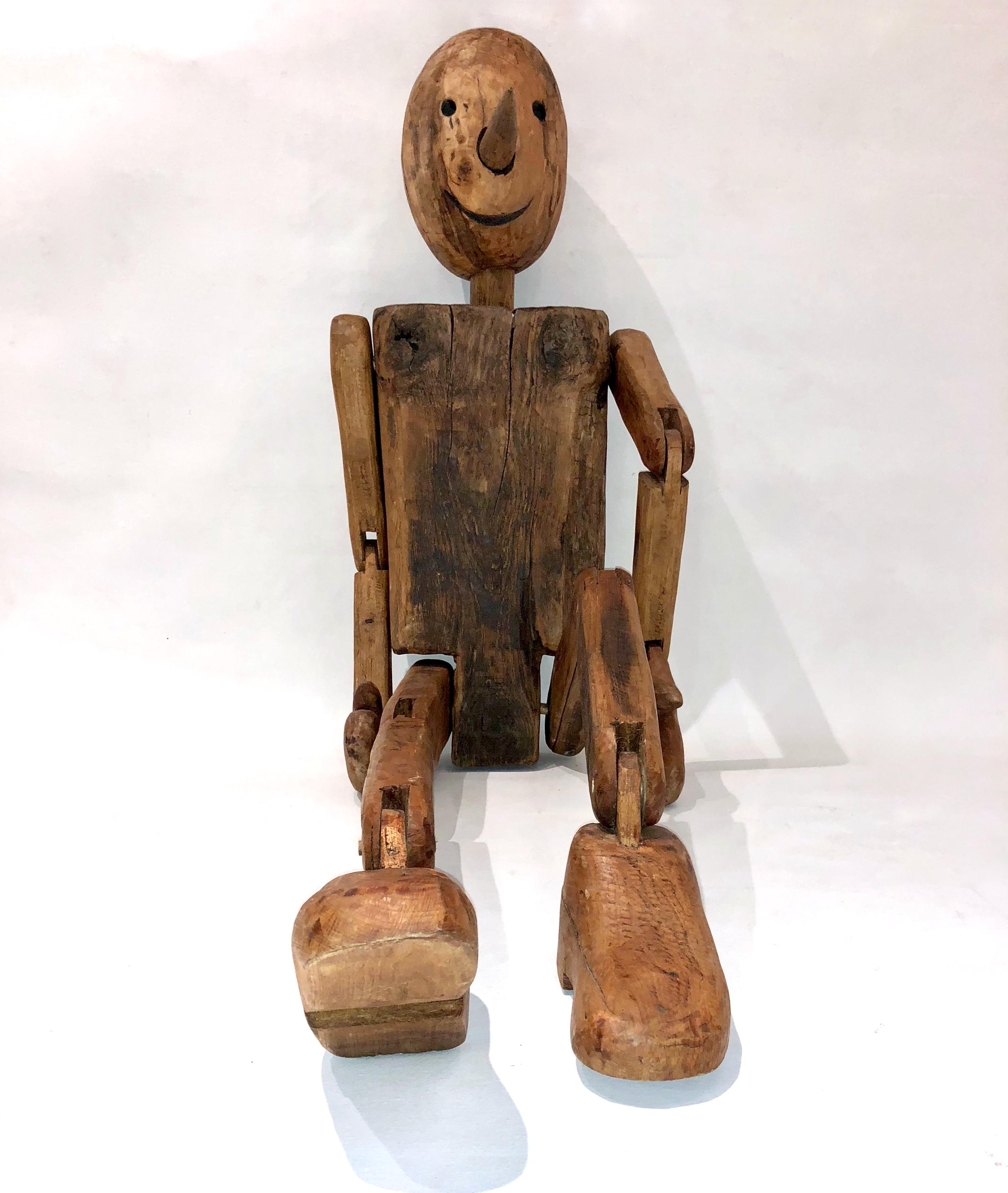 A mid-20th century life-sized Pinocchio modern Folk Art sculpture found in Tuscany, Italy, hand carved in Italian walnut and oak, high quality of the organic execution with articulated arms, hands, legs and feet, rare fun and expressive Work of Art.