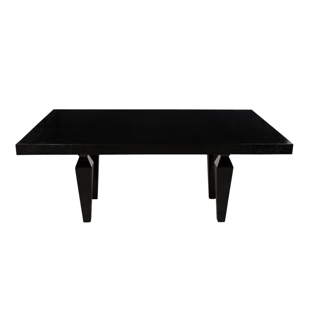This 1960s Modern-style dining table has been professionally restored and has been stained in rich black color with a newly lacquered finish. The table has a rectangular top with pull out supports for two extra leaves, rests on four sturdy