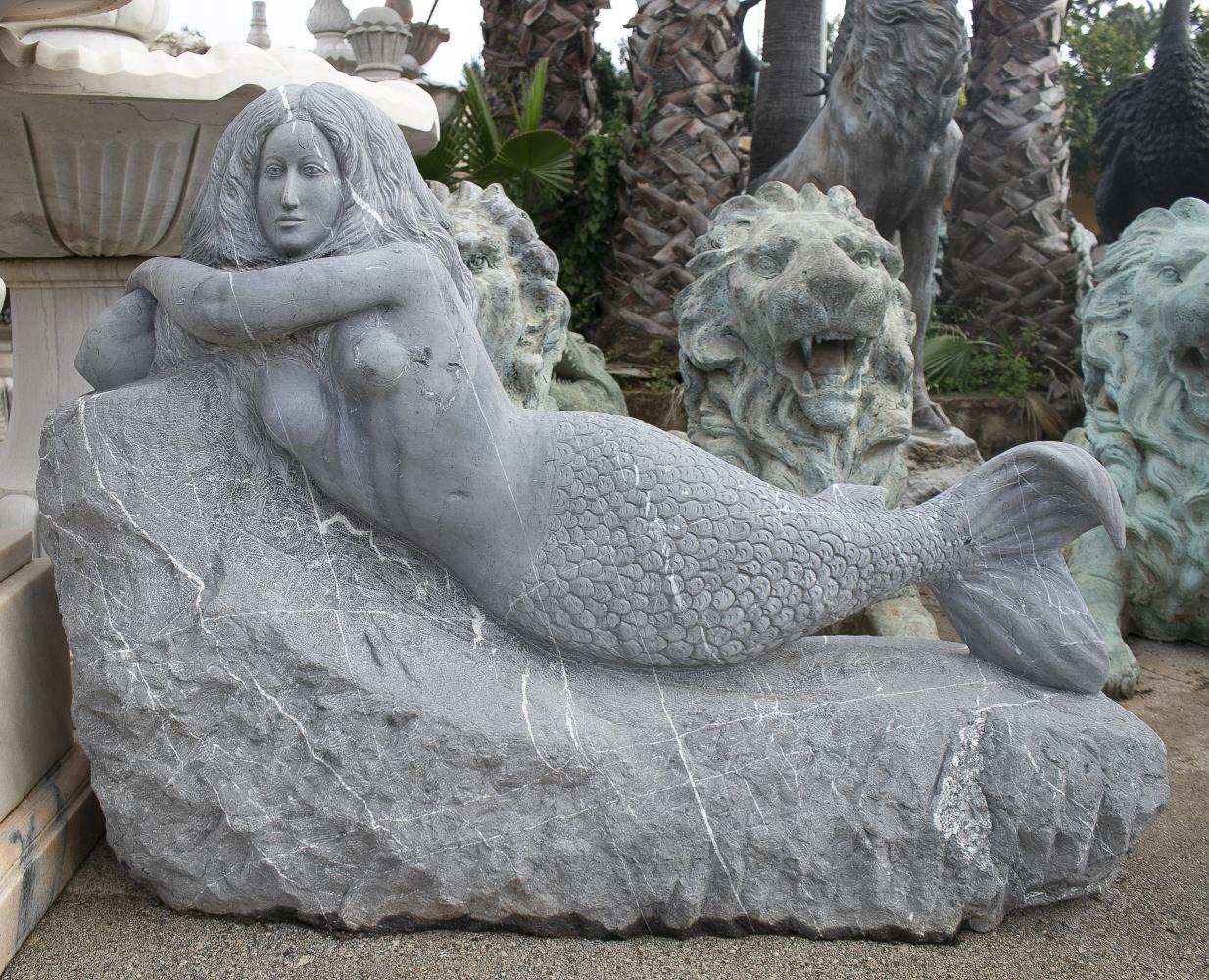Modern 1980s Spanish hand carved Belgium black mermaid laying on a rock sculpture.