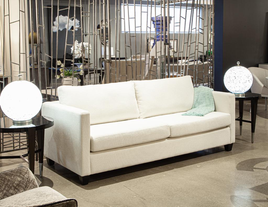 Bringen Sie mit diesem handgefertigten, modernen Sofa schlichte Eleganz und außergewöhnlichen Komfort in Ihren Wohnbereich. Er besteht aus einem stabilen Rahmen aus massivem Ahornholz und zeichnet sich durch ein schlichtes, minimalistisches Design