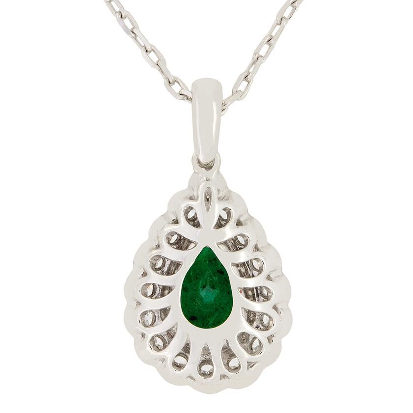 Un meraviglioso smeraldo a forma di pera da 2,00 carati fa bella mostra di sé in questo moderno pendente. È circondato da un'aureola di sedici diamanti tondi e brillanti, tutti di qualità equivalente, classificati come F nel colore e VS nella